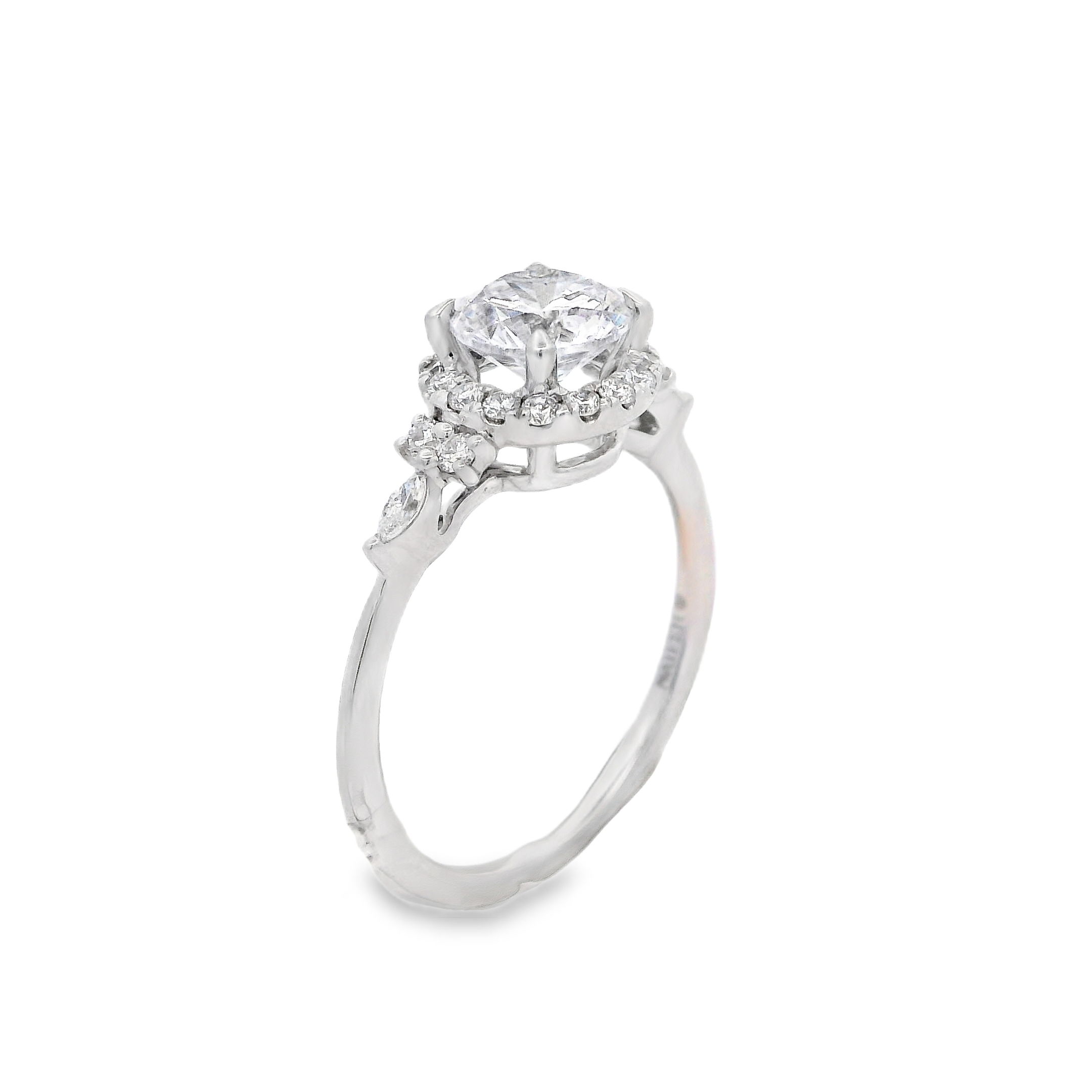 This elegant 18k white gold semi-mount features a delicate round halo surrounding the center stone, complemented by round and marquise side diamonds. The dainty halo and unique side diamond shapes create a refined, sparkling design that enhances the center stone’s brilliance for timeless sophistication. (Center stone not included)-18kt White gold-Round, Marquise diamonds, 0.28cts-Size 6.5, Contact for sizing optionsItem# 140-00223 Halo Mounting