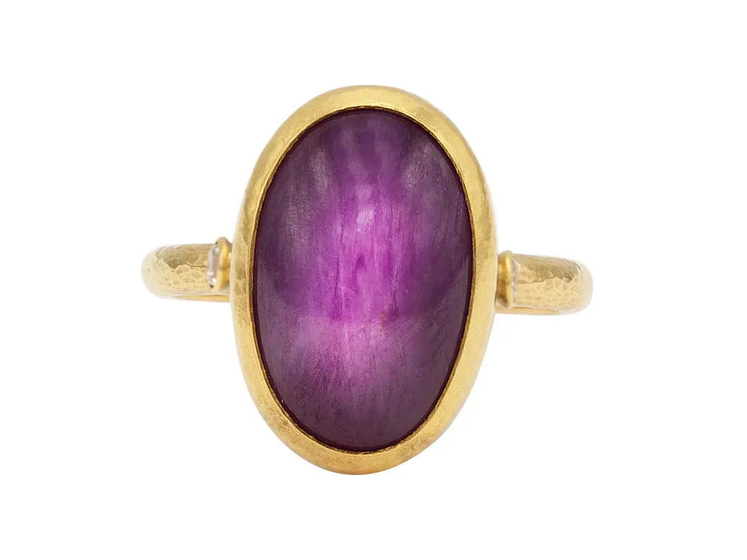 This 24k yellow gold ring showcases a stunning cabochon amethyst accented with sparkling diamonds. Its bold yet refined design adds a touch of luxury to any look.-24k Yellow gold-Cabochon amethyst, 32.39ct-Rose cut diamonds, 0.76cts-Size 7.5Item# 001-804-00819 Amethyst Ring