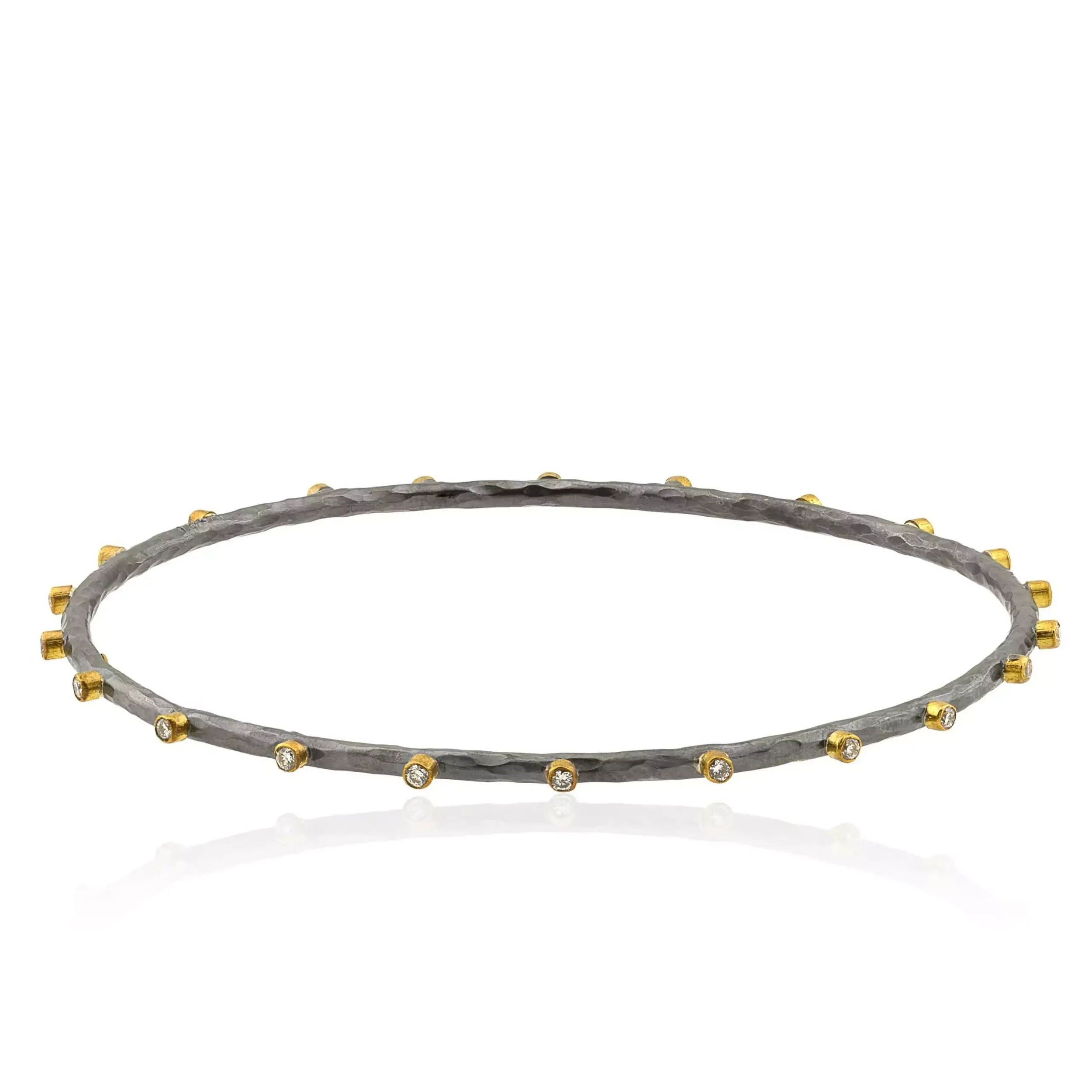 Discover timeless sophistication with the 24k yellow gold and oxidized silver Dima bracelet. Enhanced by the brilliance of diamonds, this bangle bracelet combines modern design with enduring elegance.-Oxidized silver-24k Yellow gold-Diamonds, 0.32cts-Size 7 Item# 001-808-00974 Oxidized Silver and Gold Bangle
