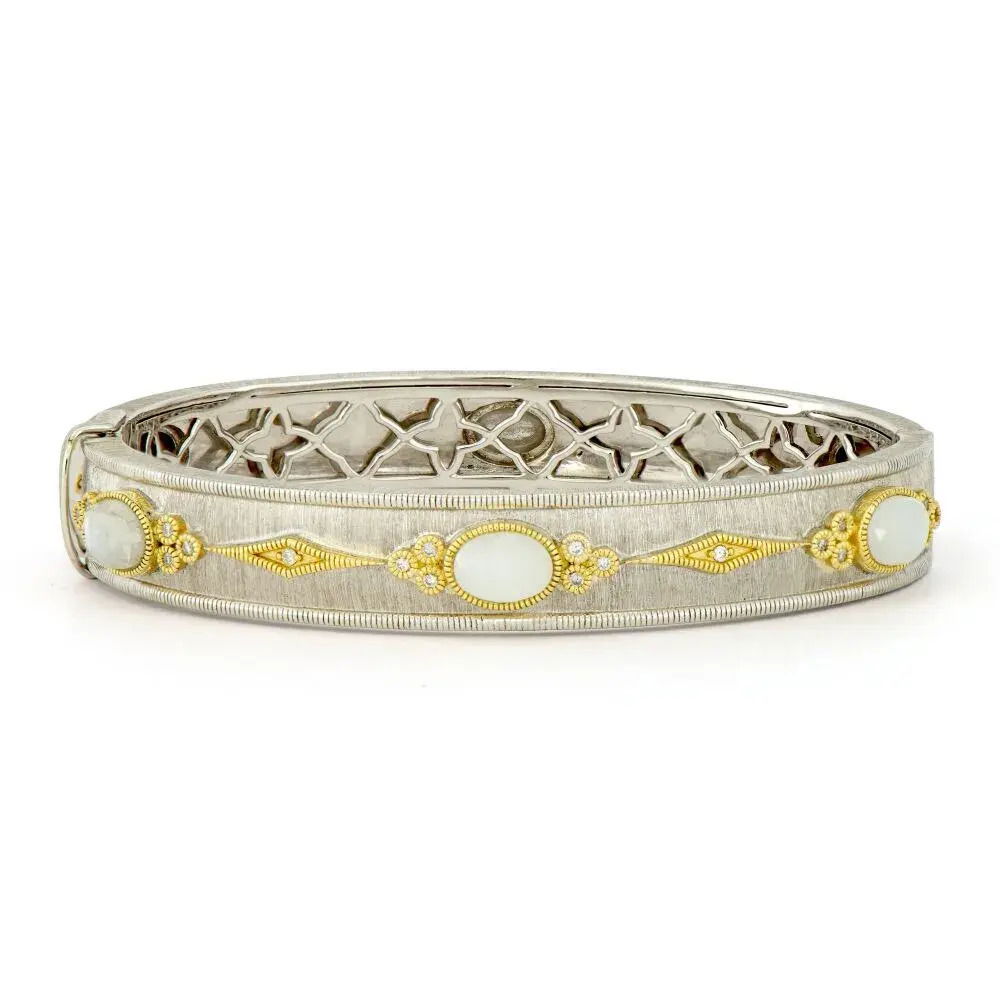 Combining classic elegance with on trend shapes and styles, JFJ offers something for women of all ages. From the Mixed Metal Collection, this bangle features three cabochon moonstones with white diamond trios on both sides and elongated white diamond kites in 18k yellow gold trim on a sterling silver band. All set in the signature brushed JFJ finish.-18k Yellow gold-Round white diamonds, 0.22cts-Moonstone-Dimensions, 10mm-Size, 6.5Item# 808-01042 Mixed Metal Oval Moonstone Bangle