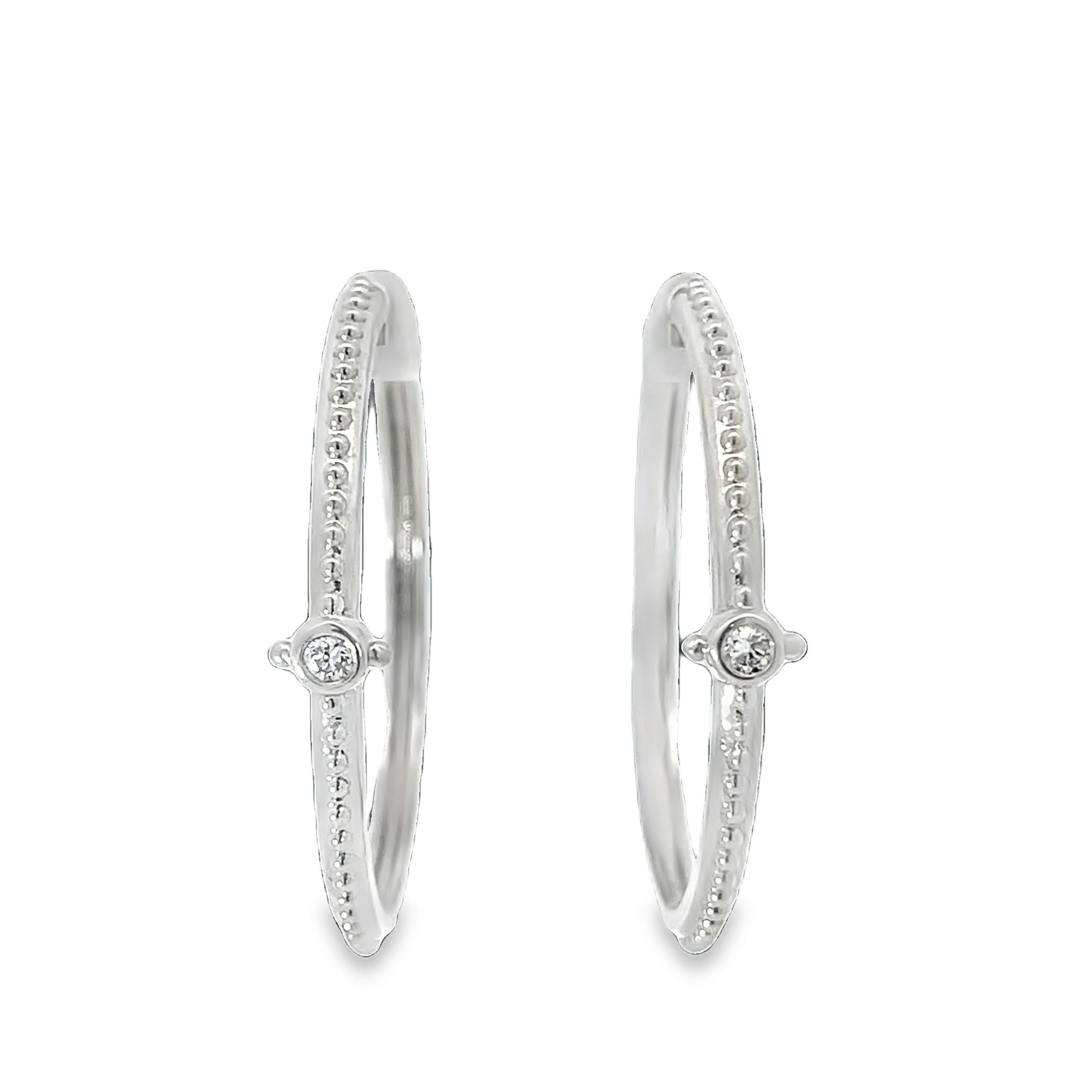 These 18k white gold huggie earrings feature sparkling round diamonds. Their sleek and timeless design makes them perfect for everyday elegance or special occasions.-18k White gold-Round diamonds, 0.14ctsItem# 805-01392 White Gold Huggie Earrings with Diamonds
