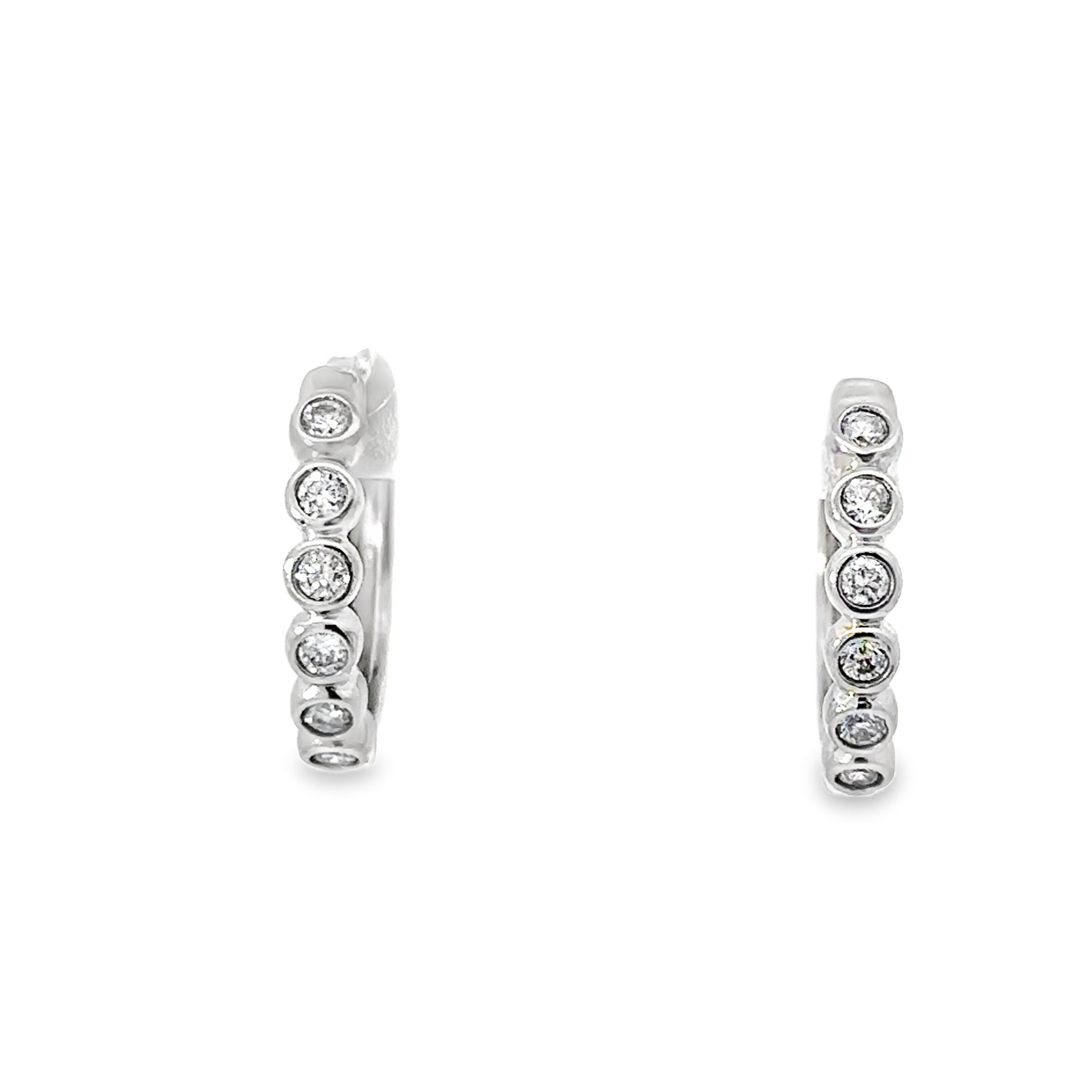 These huggies feature sparkling diamonds set in sleek bezel settings, creating a modern and refined look. Their close-fitting design makes them perfect for everyday elegance or adding a touch of sophistication to any outfit.-14k White gold-Round white diamonds, 0.21ctsItem# 805-01689 Diamond Bezel Huggies