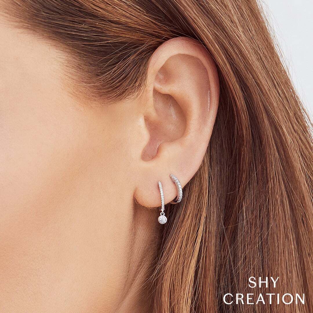 Sleek yet captivating, this minimalist piece is designed to draw attention. All Shy Creation diamonds are natural and hand-selected. All stones are unique and hand set. As a result, you can expect slight variations in the shade, hue, tint of the color stones and stone count.-14k White gold-Round diamonds, 0.07cts-0.45"L / 0.06"WItem# 805-2000031 Diamond Huggie Earrings