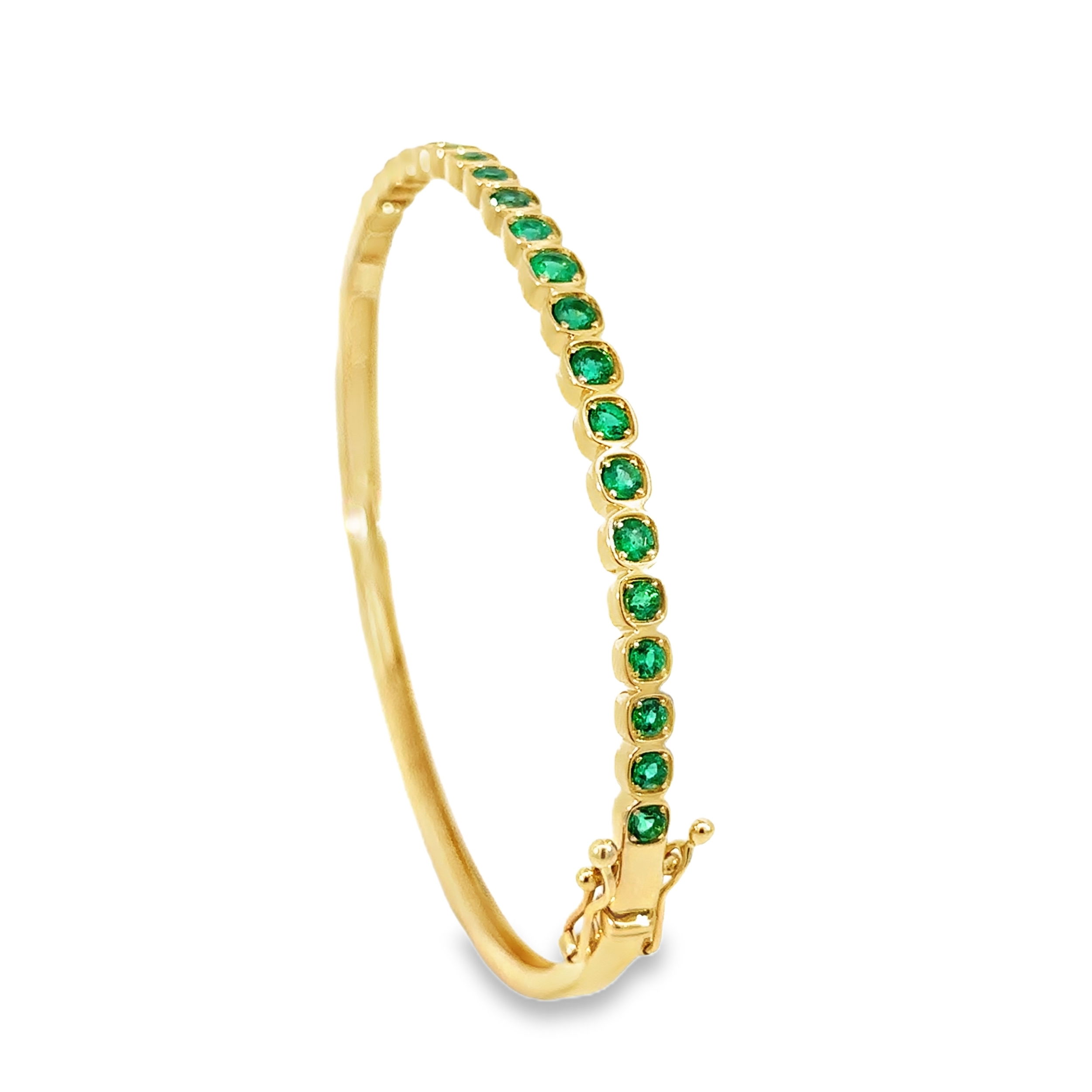 This bangle features a continuous line of round green emeralds, set with precision to create a vibrant and elegant design. With an easy and secure clasp, it offers both style and functionality, making it a perfect addition to any jewelry collection or stack.-14k Yellow gold-Round green emeralds, 1.17ctsItem# 808-01006 Emerald Bangle