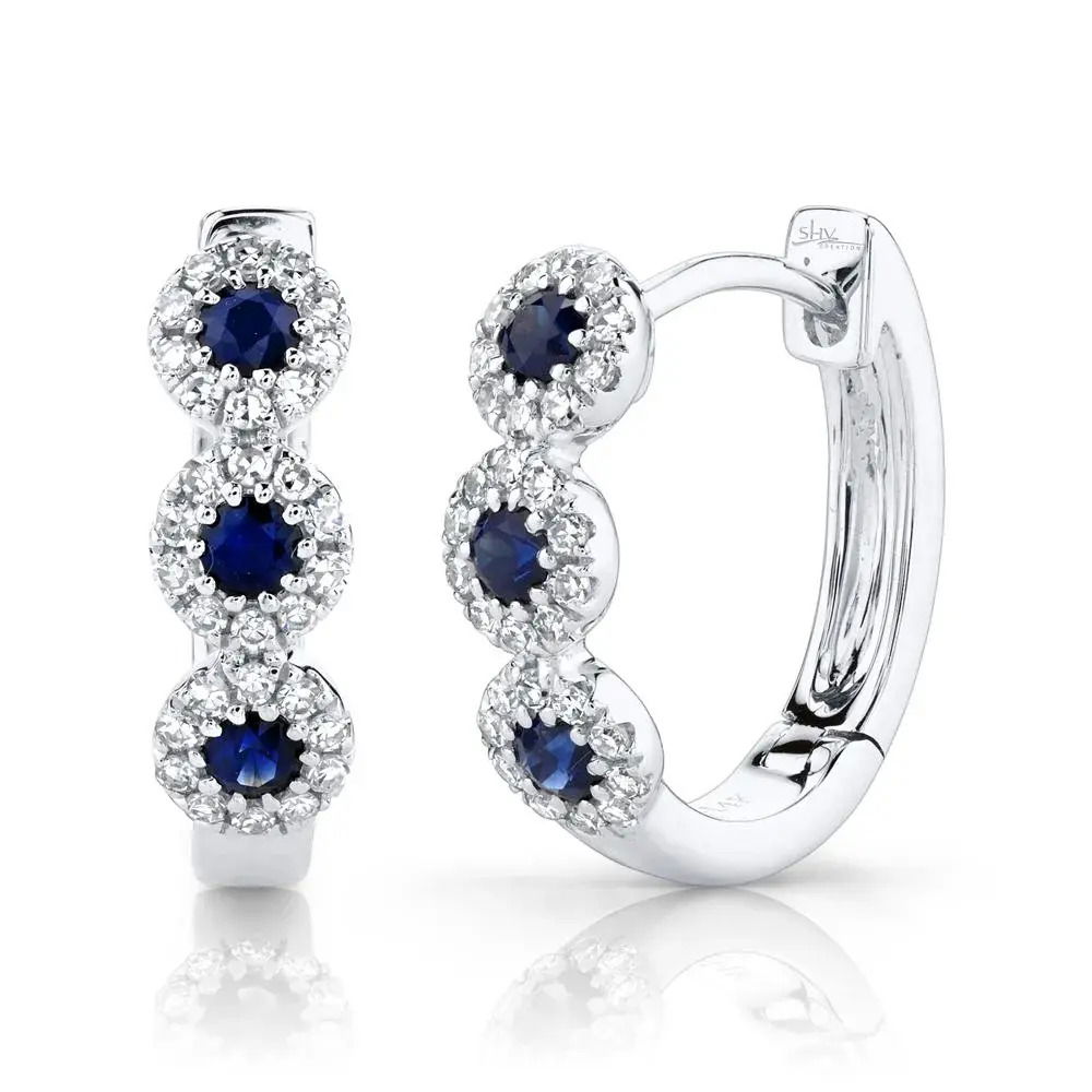 This striking piece guarantees to turn heads and start conversations wherever you go. All Shy Creation diamonds are natural and hand-selected. All stones are unique and hand set. As a result, you can expect slight variations in the shade, hue, tint of the color stones and stone count.-14k White gold-Round diamonds, 0.15cts-Round blue sapphires, 0.30cts-Dimensions, 0.55"L / 0.15"WItem# 805-2000228 Diamond & Blue Sapphire Huggie Earrings