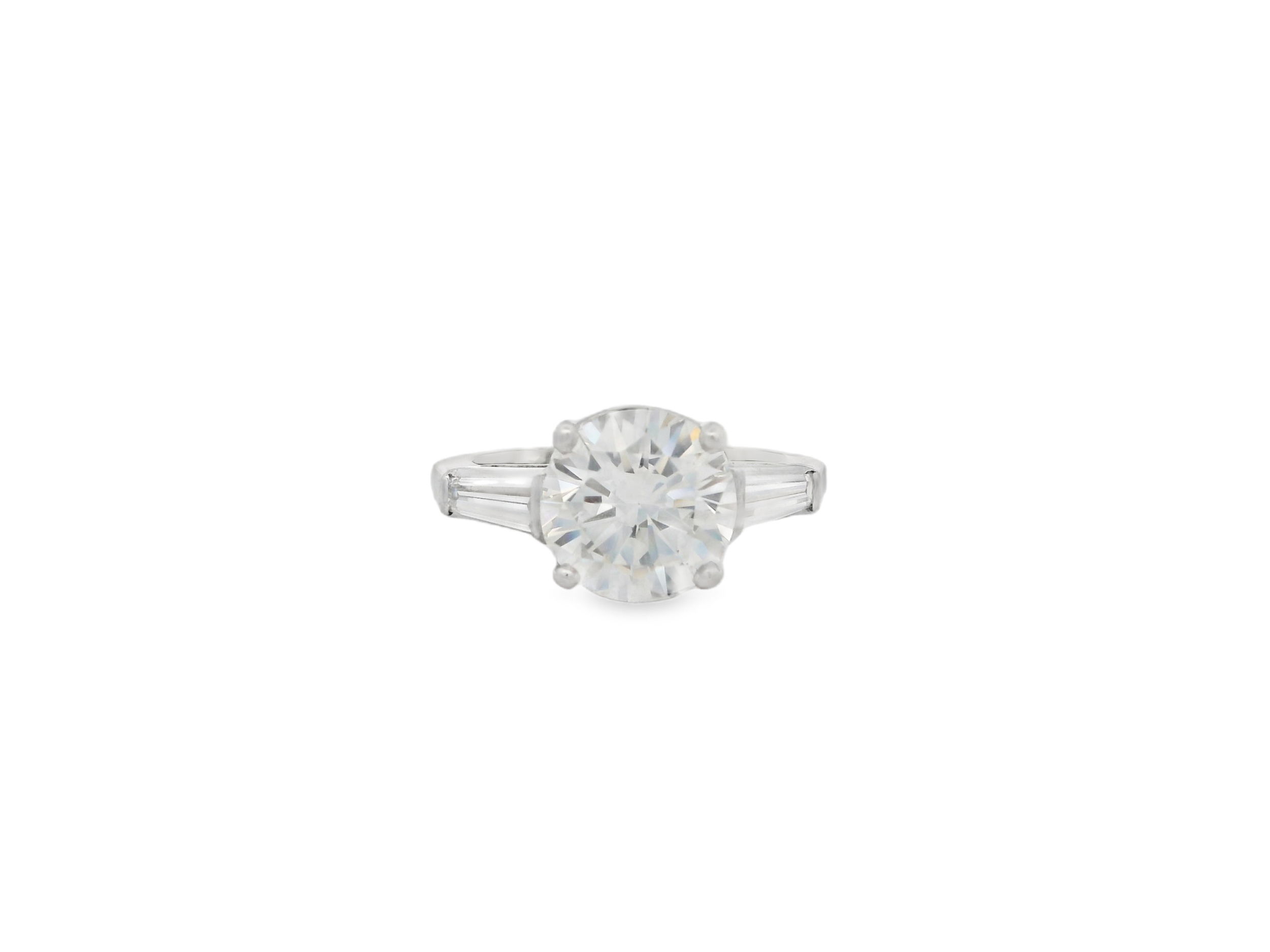 A timeless three-stone design, this Platinum ring features a dazzling 2.68ct round diamond flanked by tapered baguettes for a refined, balanced look. The classic silhouette symbolizes your past, present, and future—perfectly capturing the essence of enduring love.-Platinum-Round diamond, 2.68cts-Baguette diamonds, 0.60cts-Size 4.25, Contact for sizing optionsItem# 100-2000014 Three Stone Engagement Ring