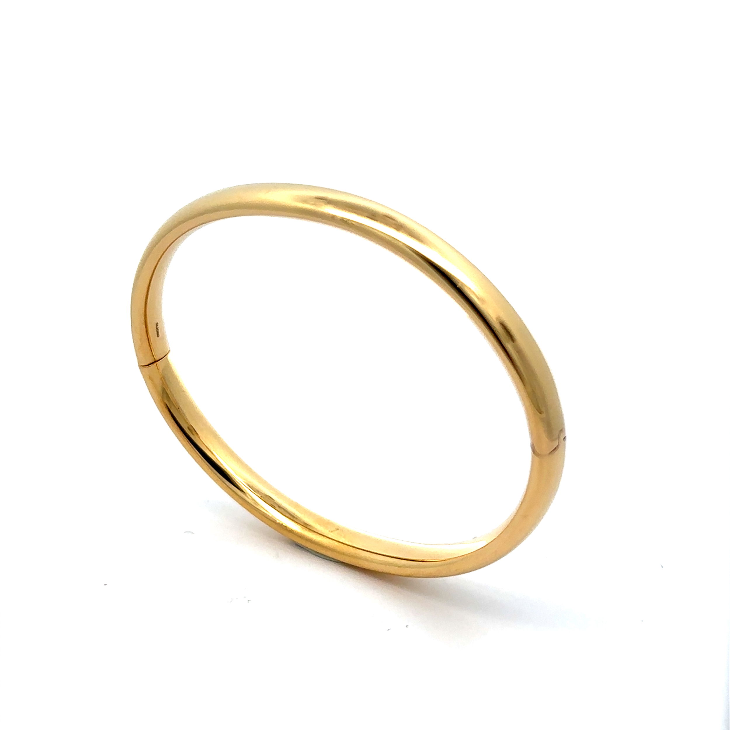 This simple polished gold bangle exudes timeless elegance with its sleek, smooth design. Its minimalist appeal makes it a versatile piece, ideal for stacking with other bracelets or wearing solo for a refined, understated look.-18k Yellow gold-Size 7Item# 808-2000140 Designer Hinged Bangle