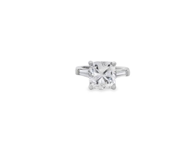 This elegant three-stone ring set in Platinum showcases a stunning 3.20ct cushion-cut diamond, flanked by sleek tapered baguettes for a timeless, sophisticated look. The classic design beautifully represents your journey together—past, present, and future—in a setting that’s both refined and enduring.-Platinum-Cushion diamond, 3.20cts-Baguette diamonds, -Size 4.75, Contact for sizing optionsItem# 100-2000032 Three Stone Engagement Ring