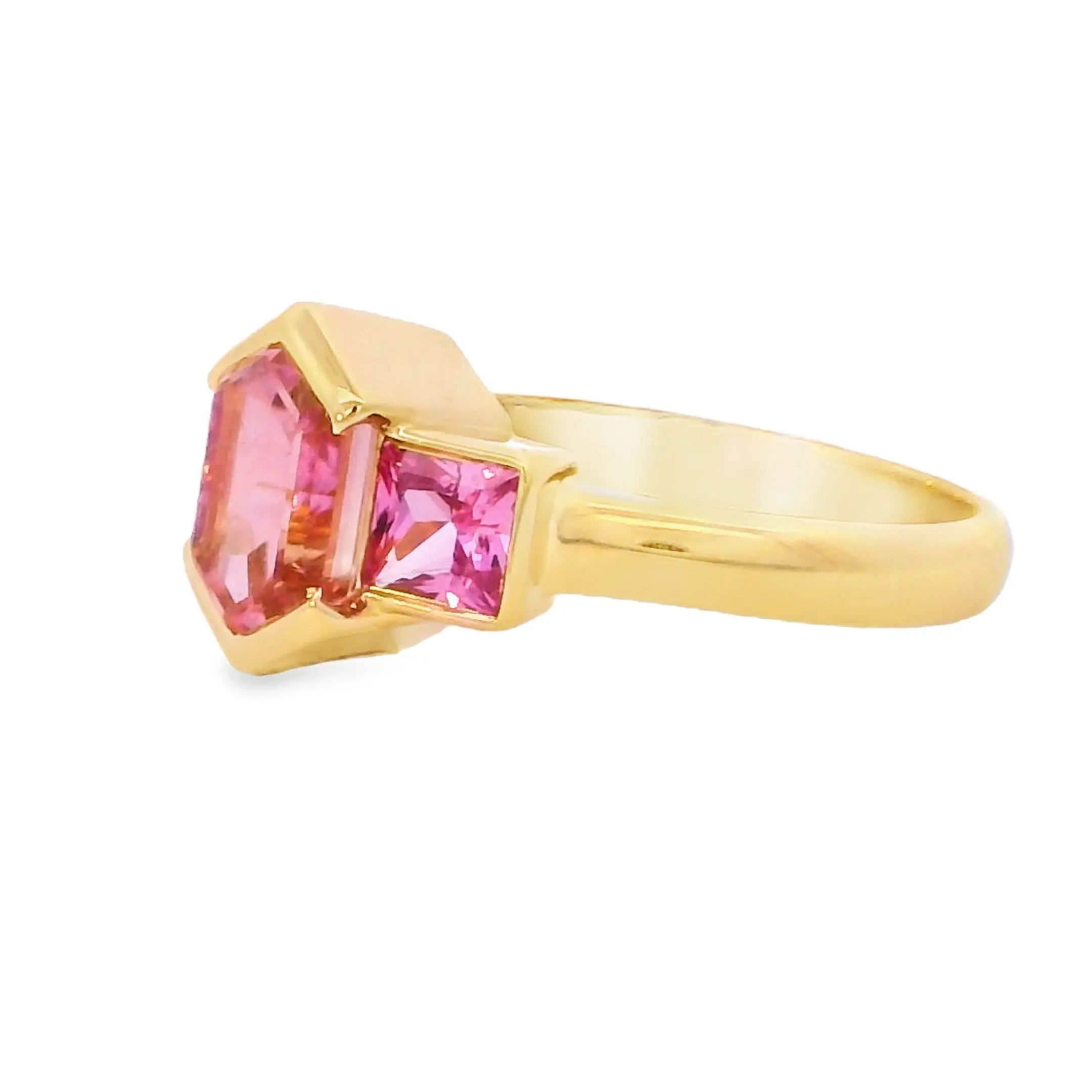 This 18k yellow gold ring features a stunning tourmaline center stone, flanked by two vibrant pink sapphires for a pop of color. Its bold design blends elegance and playfulness, making it a unique statement piece.-18k Yellow gold-Tourmaline, 1.68ct-Pink sapphires, 1.14cts-Size 6.5Item# ND-Ring-00019 Rosé Ring