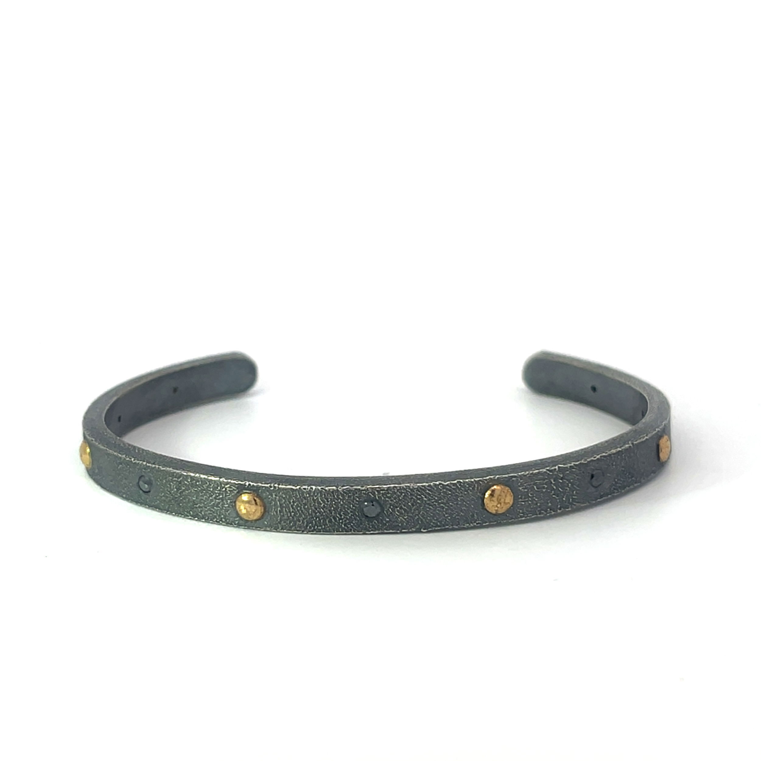This cuff features a bold, textured finish that highlights its raw, artisanal character. Accented with diamond and gold details, it creates a striking contrast that blends modern elegance with a rugged, contemporary edge.-22k Yellow gold-Oxidized stainless steel-Round black diamondsItem# 610-2000002 Black Diamond & Gold Accent Oxidized Cuff Bracelet