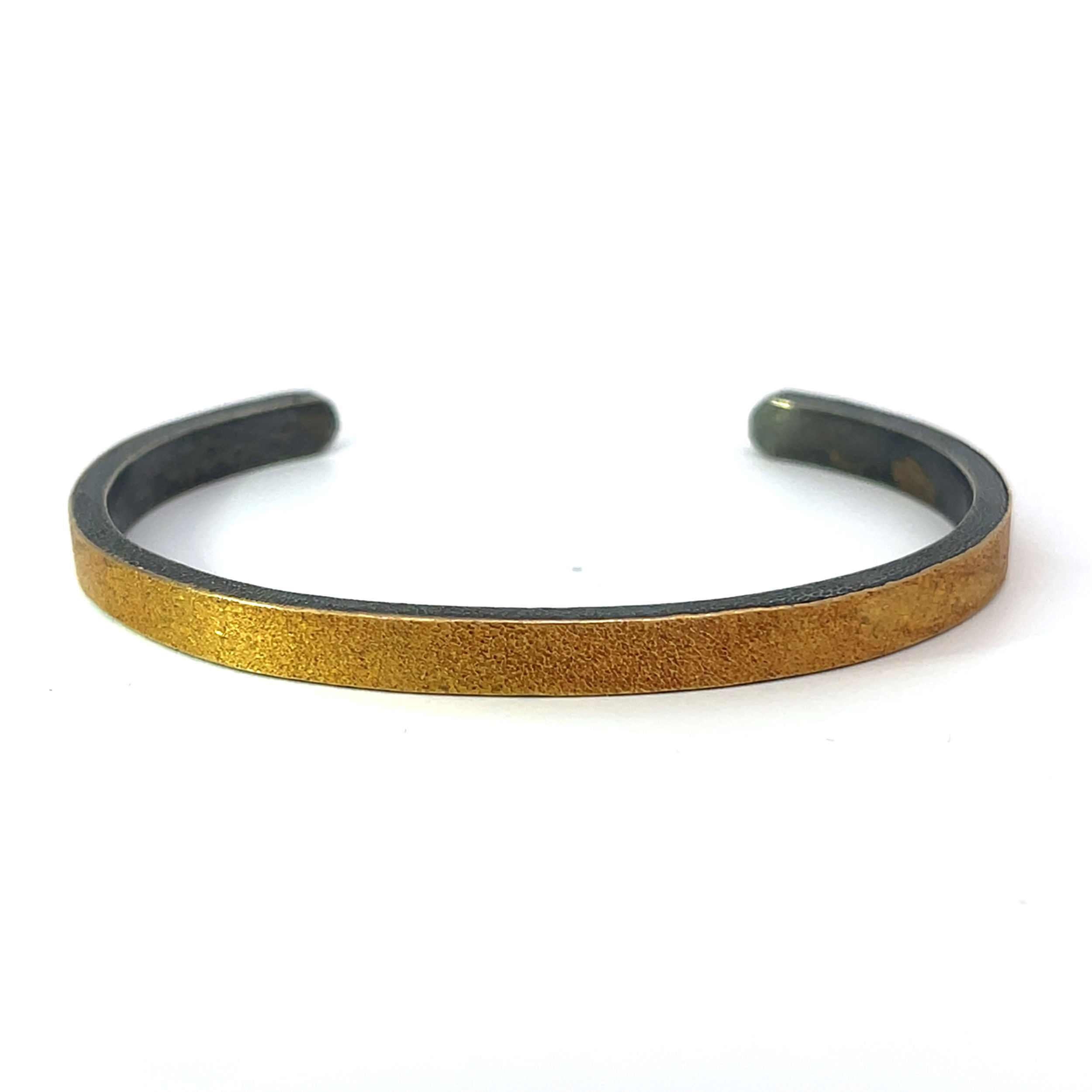 This cuff blends the richness of 22k gold with the bold, textured contrast of oxidized sterling silver. This creates a striking, modern design that adds depth and sophistication to any look.-22k Yellow gold-Oxidized stainless steelItem# 610-2000005 22K & Oxidized Sterling Silver Gold Wrap
