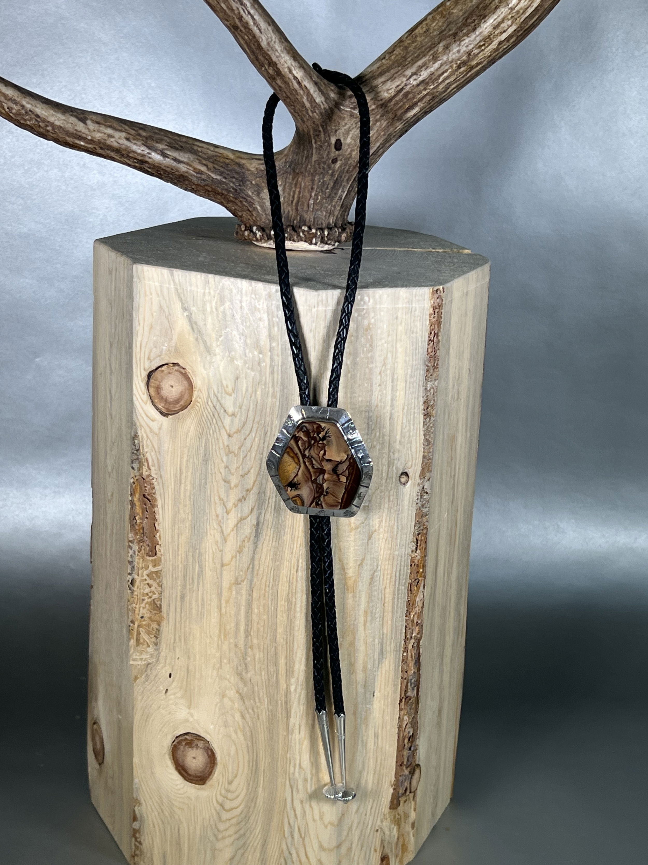 Elevate your style with our Arroyo Biggs Jasper Bolo. Hand-crafted locally, this unique bolo tie features a stunning Oregon Biggs Jasper or "Picture Jasper" stone set in sleek, silver hardware. Add a touch of sophistication to any outfit with this luxurious accessory that will surely make a statement.-Sterling Silver-Jasper-LeatherItem# 24643640 Arroyo Biggs Jasper Bolo