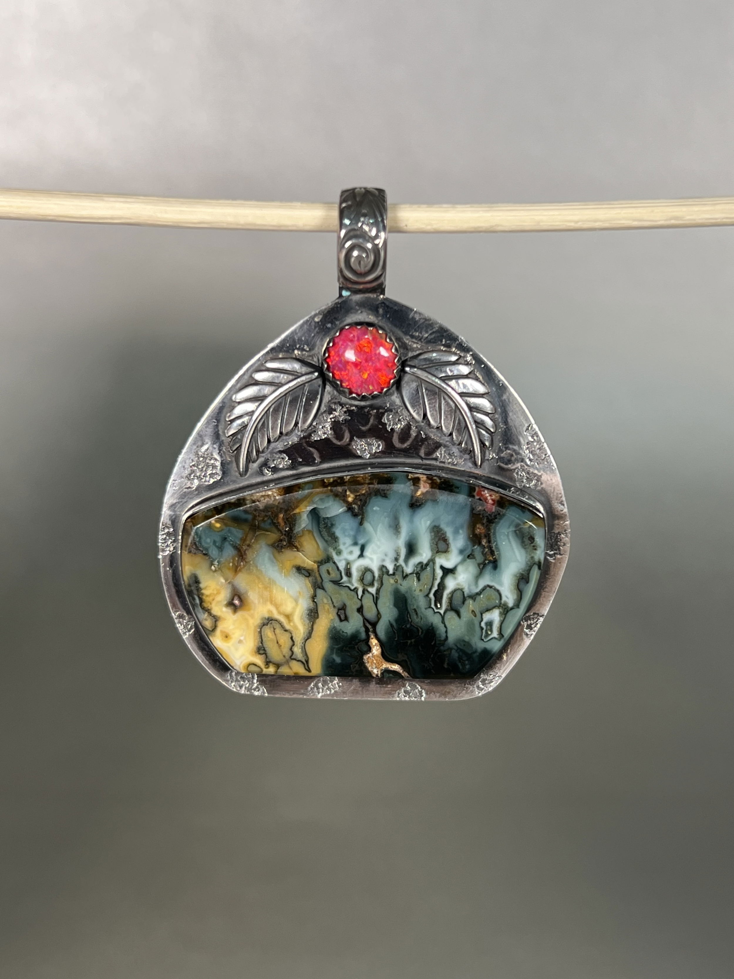 Indulge in the natural beauty of the Magic Moon Midnight Blue Plume Agate Pendant. With agate mined and hand-crafted locally in Sun Valley Idaho, this one-of-a-kind piece boasts intricate details and a luxurious aesthetic. Elevate your style with this exclusive pendant and embrace the artistry and authenticity of local craftsmanship. Features a Midnight Blue Agate Plume with an Indian Opal accent stone.-Sterling Silver-Agate-Indian OpalItem# 64138040 Magic Moon Midnight Blue Plume Agate Pendant