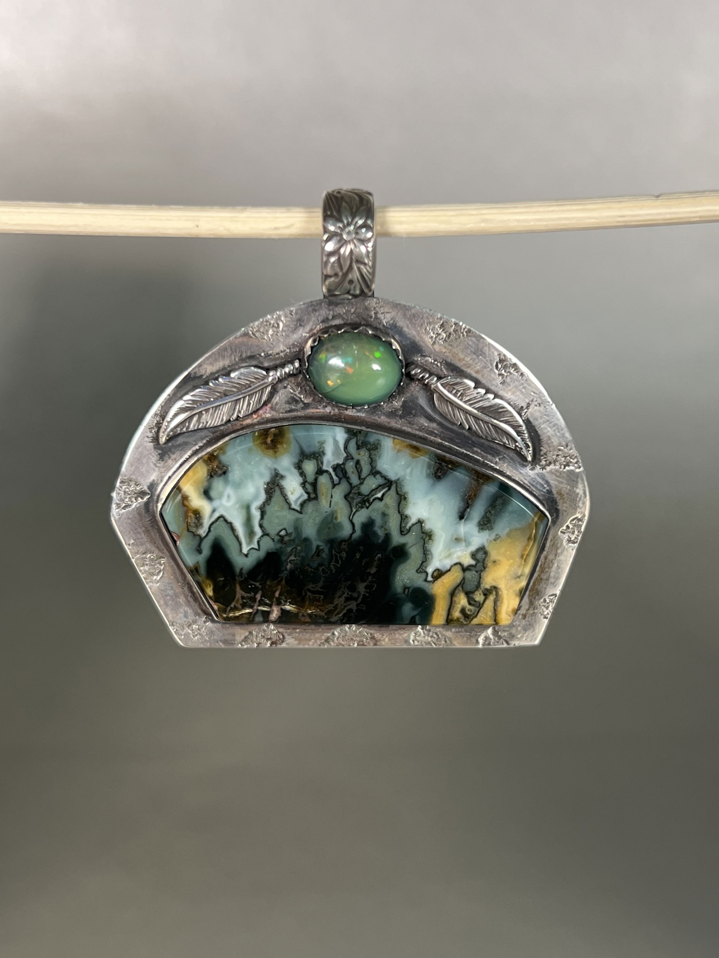 Indulge in the natural beauty of the Midnight Blue Feathers Plume Agate Pendant. With agate mined and hand-crafted locally in Sun Valley Idaho, this one-of-a-kind piece boasts intricate details and a luxurious aesthetic. Elevate your style with this exclusive pendant and embrace the artistry and authenticity of local craftsmanship. Features a Midnight Blue Plume Agate with an Ethiopian Opal accent stone.-Sterling Silver-Agate-Ethiopian opalItem# 19475256 Midnight Blue Feathers Plume Agate Pendant