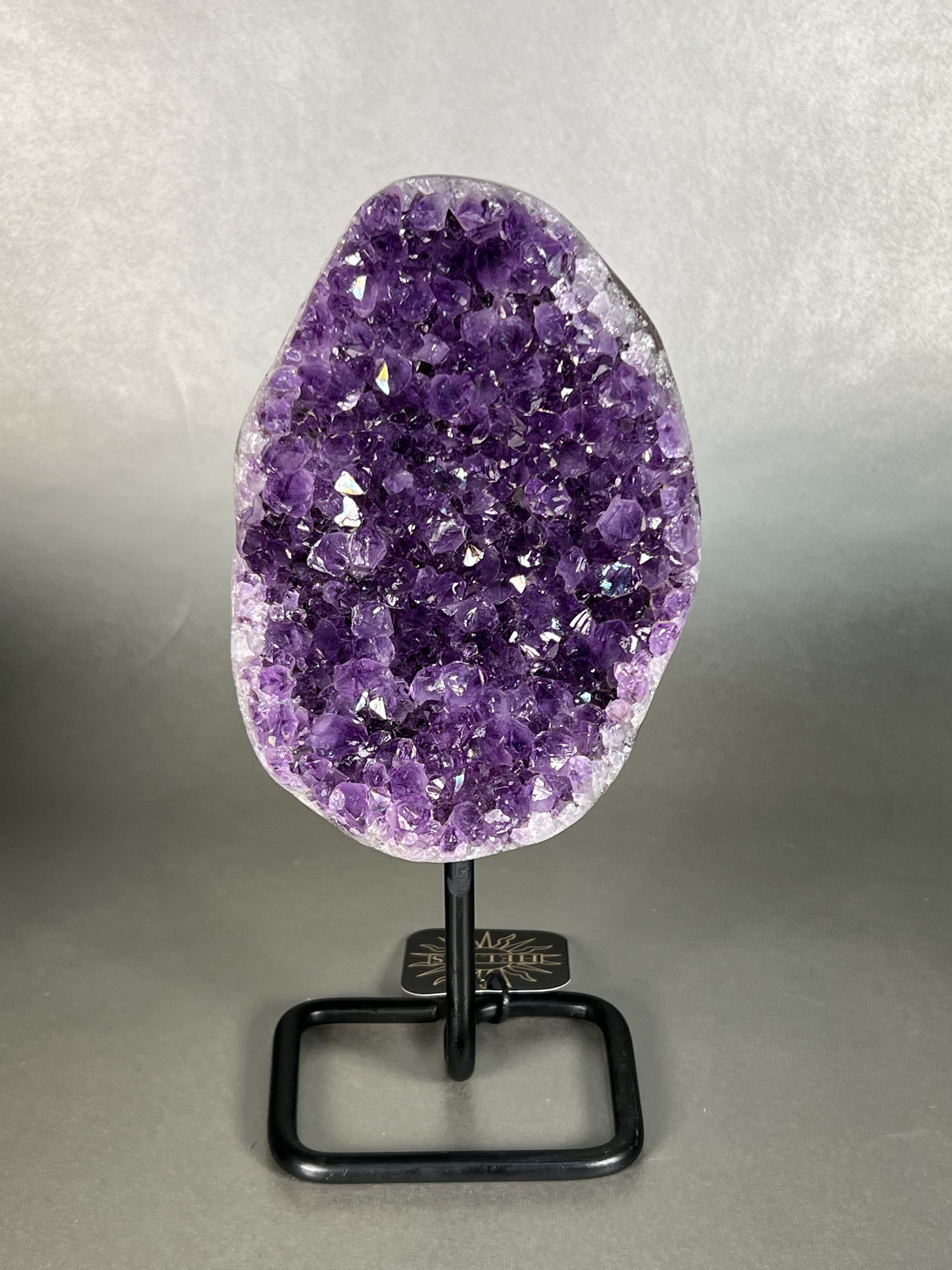 This amethyst on stand is the perfect addition to any home decor. Crafted with a premium natural amethyst crystal specimen and sturdy stand, this piece is sure to add a touch of elegance to any room. Its unparalleled beauty and durability make it a perfect long-term home accessory. Approx. 4.5" x 10" Uruguayan Amethyst On Stand