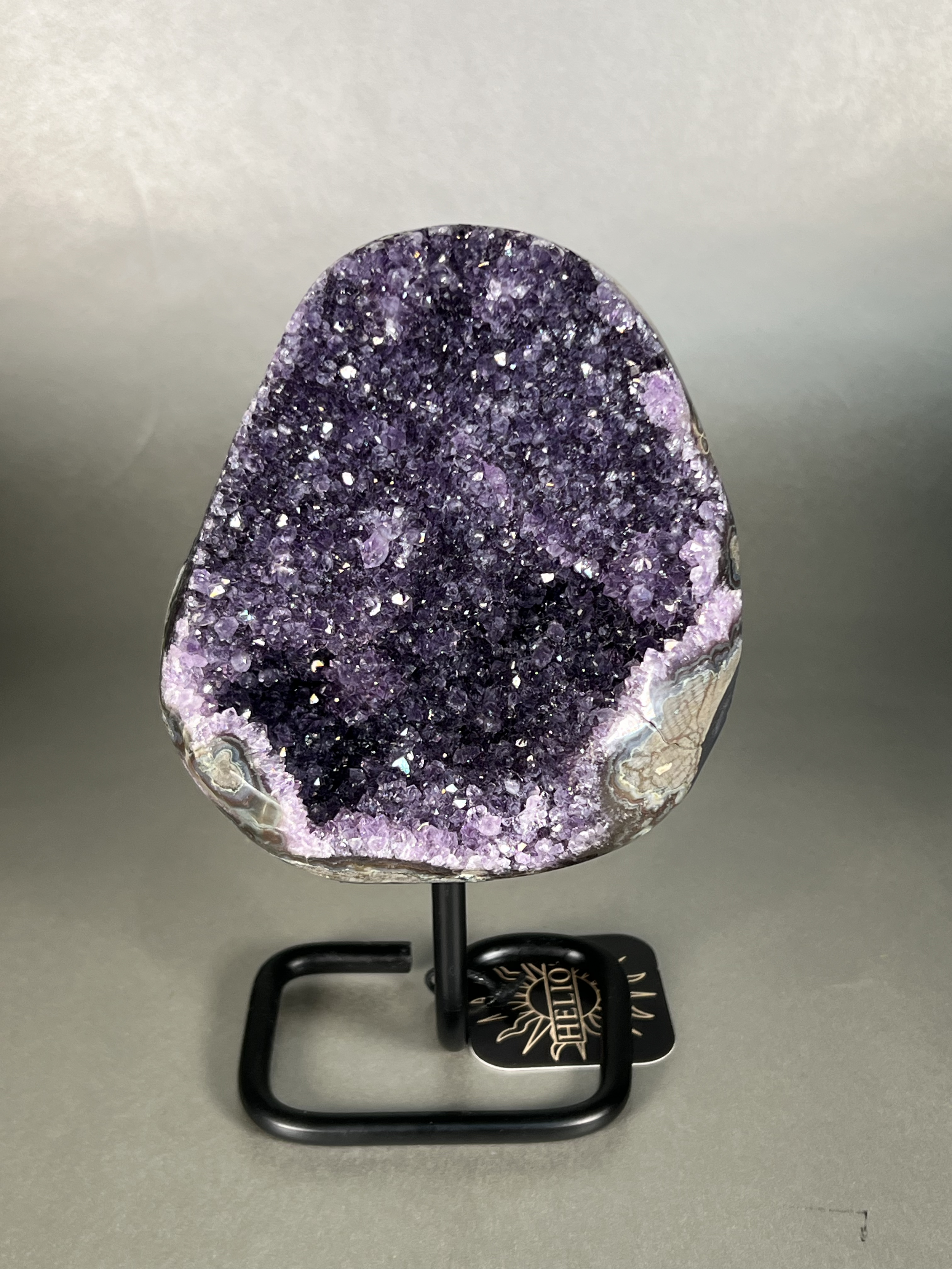 This amethyst on stand is the perfect addition to any home decor. Crafted with a premium natural amethyst crystal specimen and sturdy stand, this piece is sure to add a touch of elegance to any room. Its unparalleled beauty and durability make it a perfect long-term home accessory. Approx. 5" x 8" Uruguayan Amethyst On Stand
