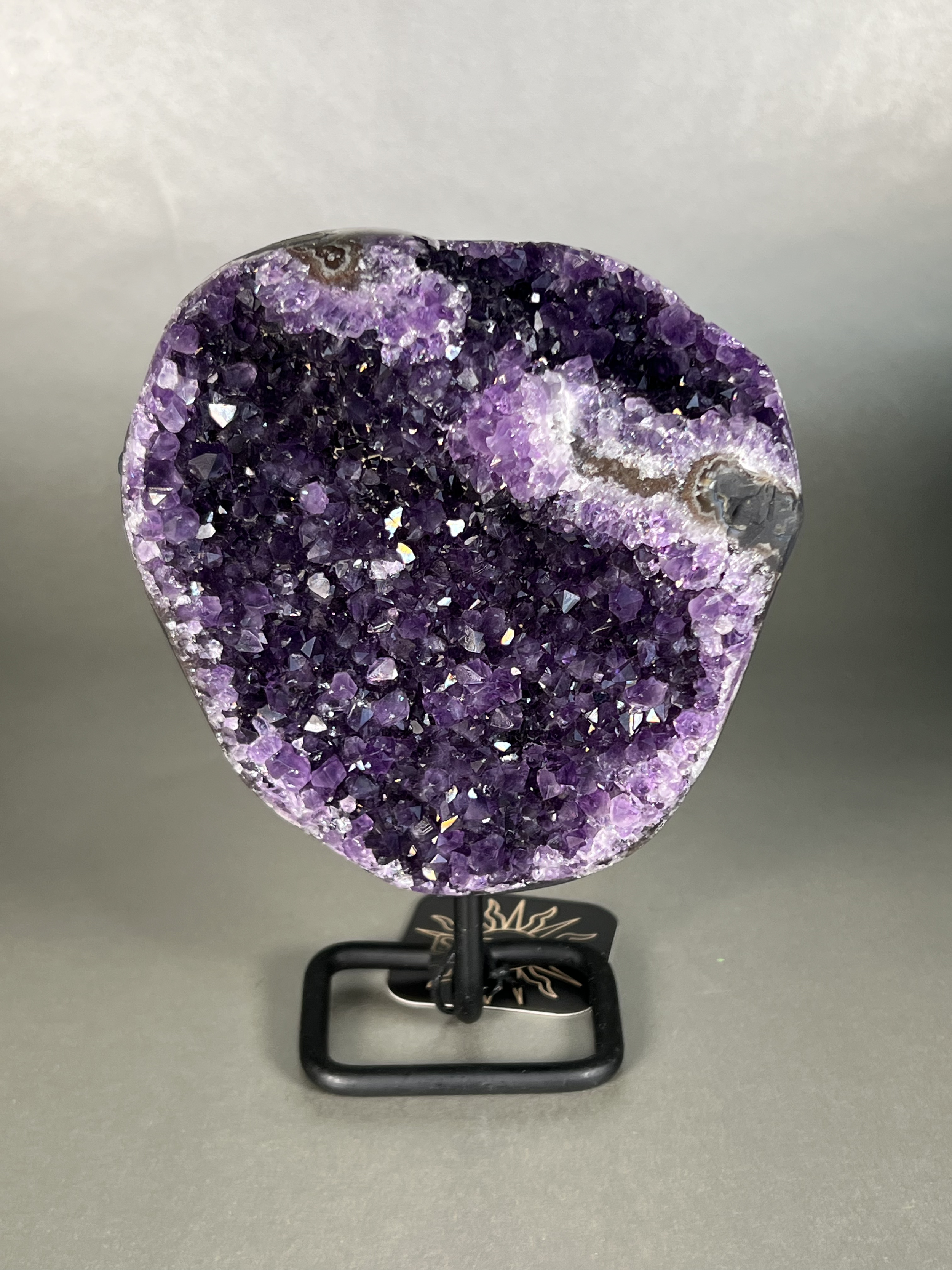 This amethyst on stand is the perfect addition to any home decor. Crafted with a premium natural amethyst crystal specimen and sturdy stand, this piece is sure to add a touch of elegance to any room. Its unparalleled beauty and durability make it a perfect long-term home accessory. Approx. 5.5" x 7.5" Uruguayan Amethyst On Stand