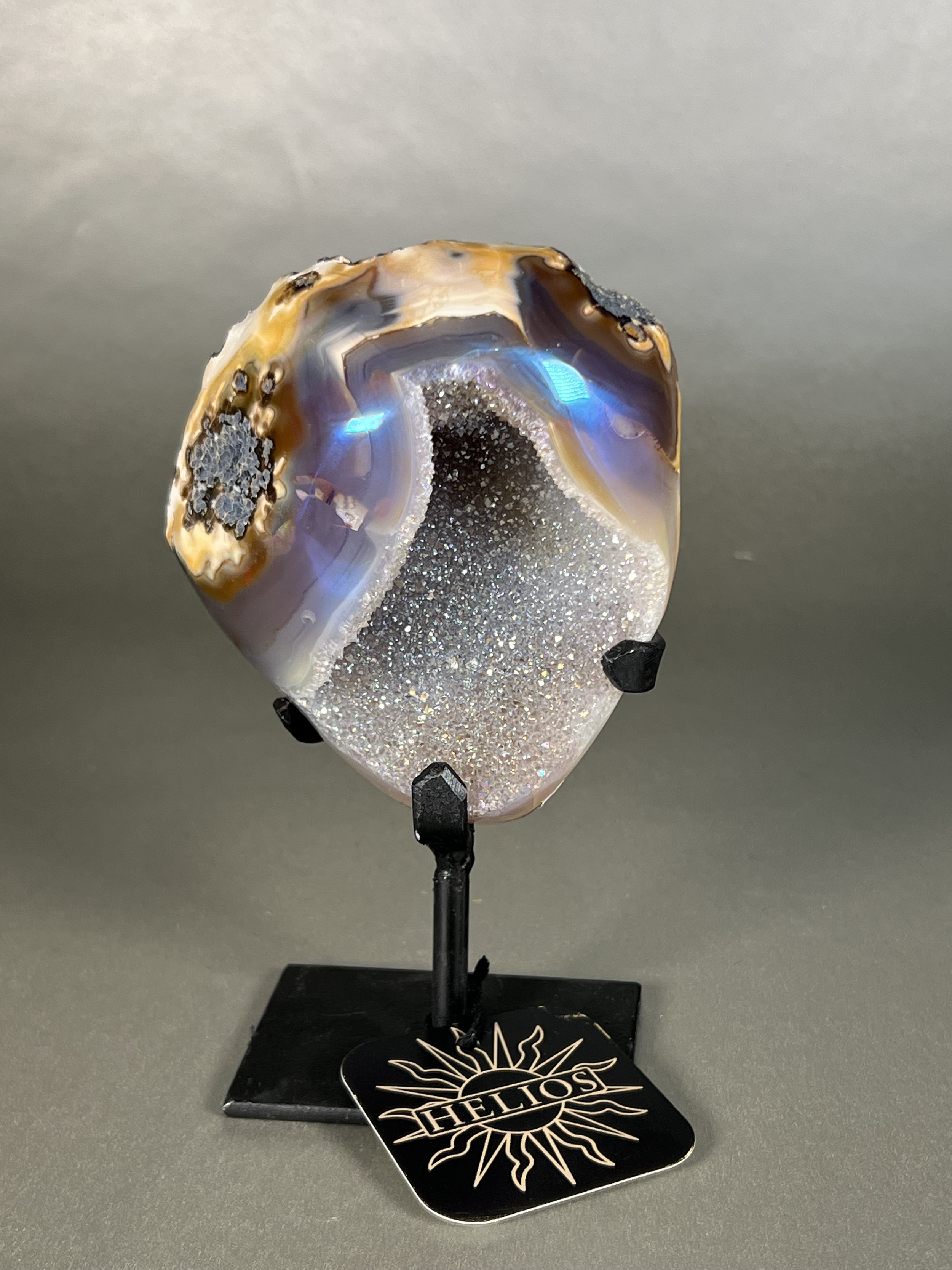 Experience the dreamy elegance of our Aura Agate Obelisk. Each one is uniquely crafted to exude a sense of luxury and exclusivity. Featuring the rare Aura Agate stone, this obelisk brings a touch of sophistication and beauty to any space. Elevate your decor with this truly one-of-a-kind piece. Approx. 4" x 6" Aura Agate Geodes On Stand