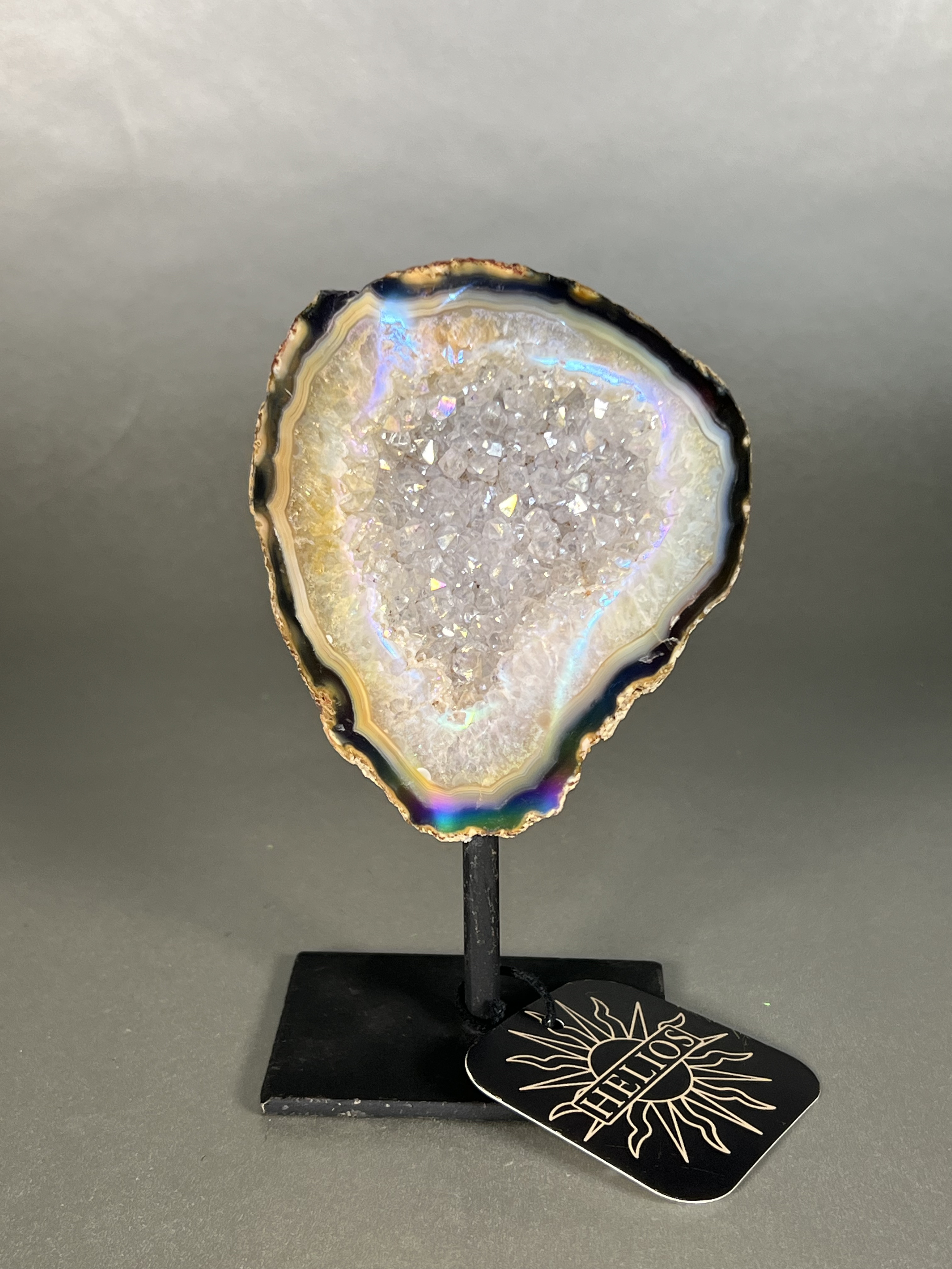 Experience the dreamy elegance of our Aura Agate Obelisk. Each one is uniquely crafted to exude a sense of luxury and exclusivity. Featuring the rare Aura Agate stone, this obelisk brings a touch of sophistication and beauty to any space. Elevate your decor with this truly one-of-a-kind piece. Approx. 4" x 6" Aura Agate Geodes On Stand