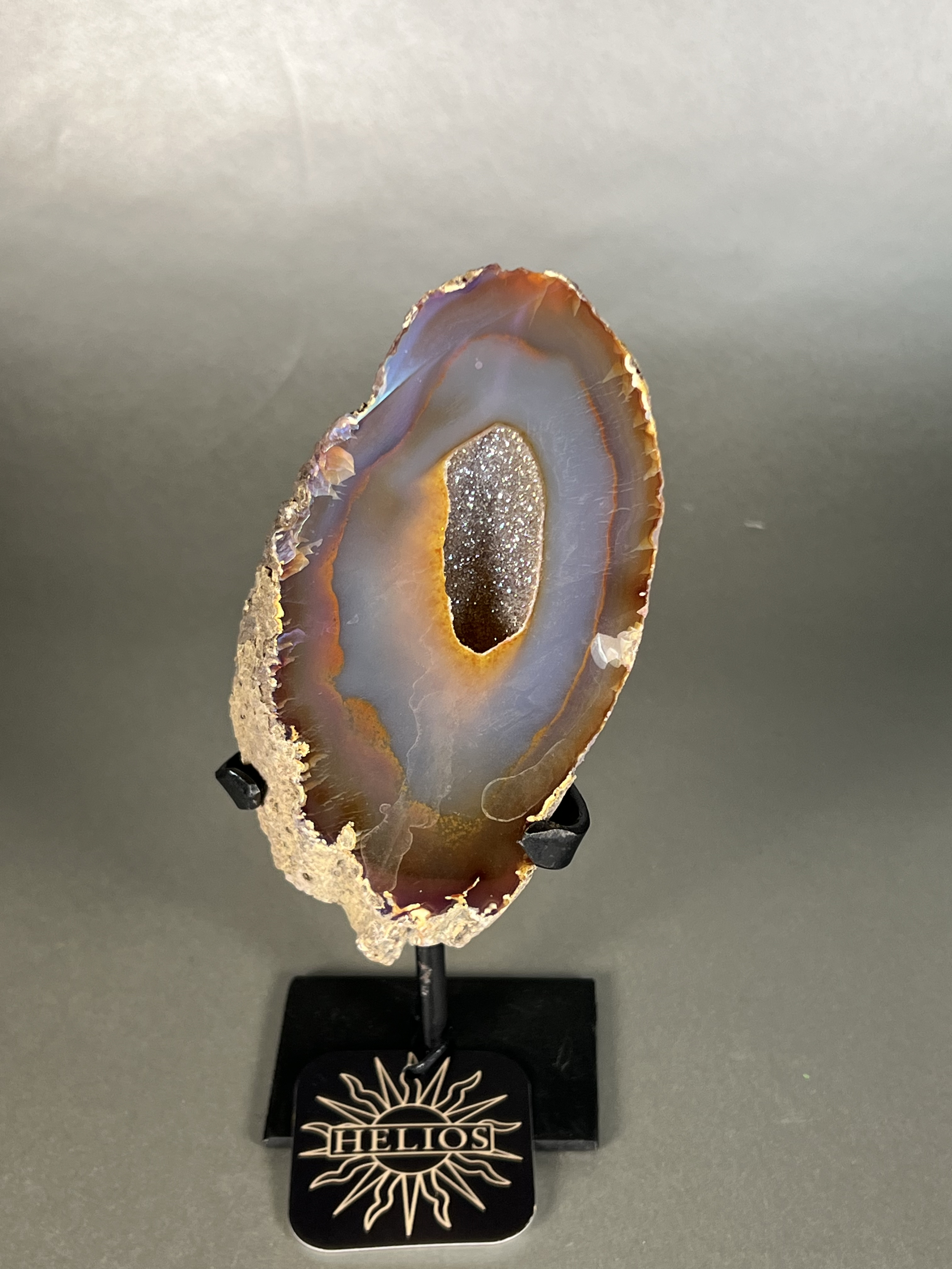 Experience the dreamy elegance of our Aura Agate Obelisk. Each one is uniquely crafted to exude a sense of luxury and exclusivity. Featuring the rare Aura Agate stone, this obelisk brings a touch of sophistication and beauty to any space. Elevate your decor with this truly one-of-a-kind piece. Approx. 4" x 8" Aura Agate Geodes On Stand