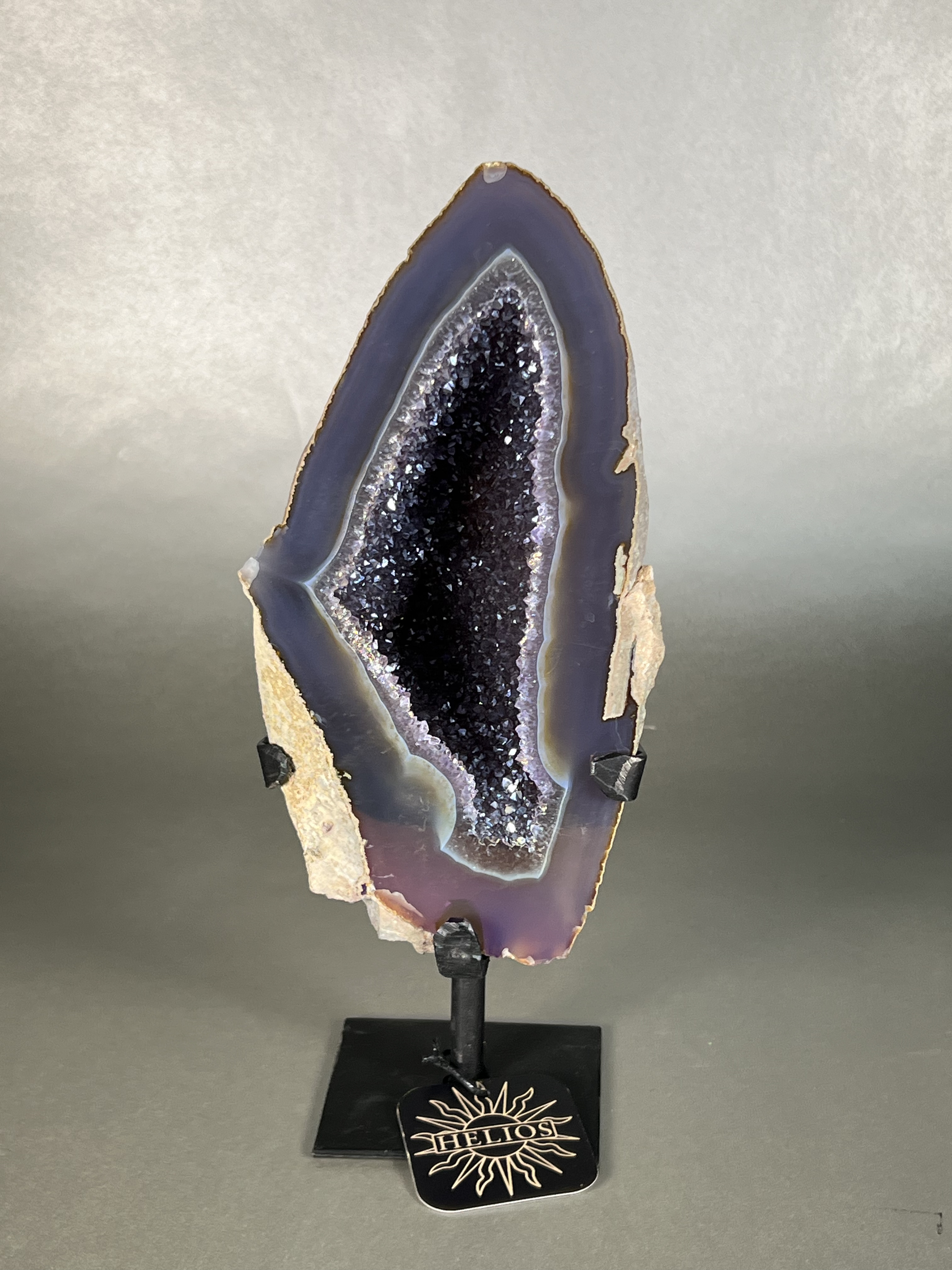 Experience the dreamy elegance of our Aura Agate Obelisk. Each one is uniquely crafted to exude a sense of luxury and exclusivity. Featuring the rare Aura Agate stone, this obelisk brings a touch of sophistication and beauty to any space. Elevate your decor with this truly one-of-a-kind piece. Approx. 4.5"x11" Aura Agate Geodes On Stand