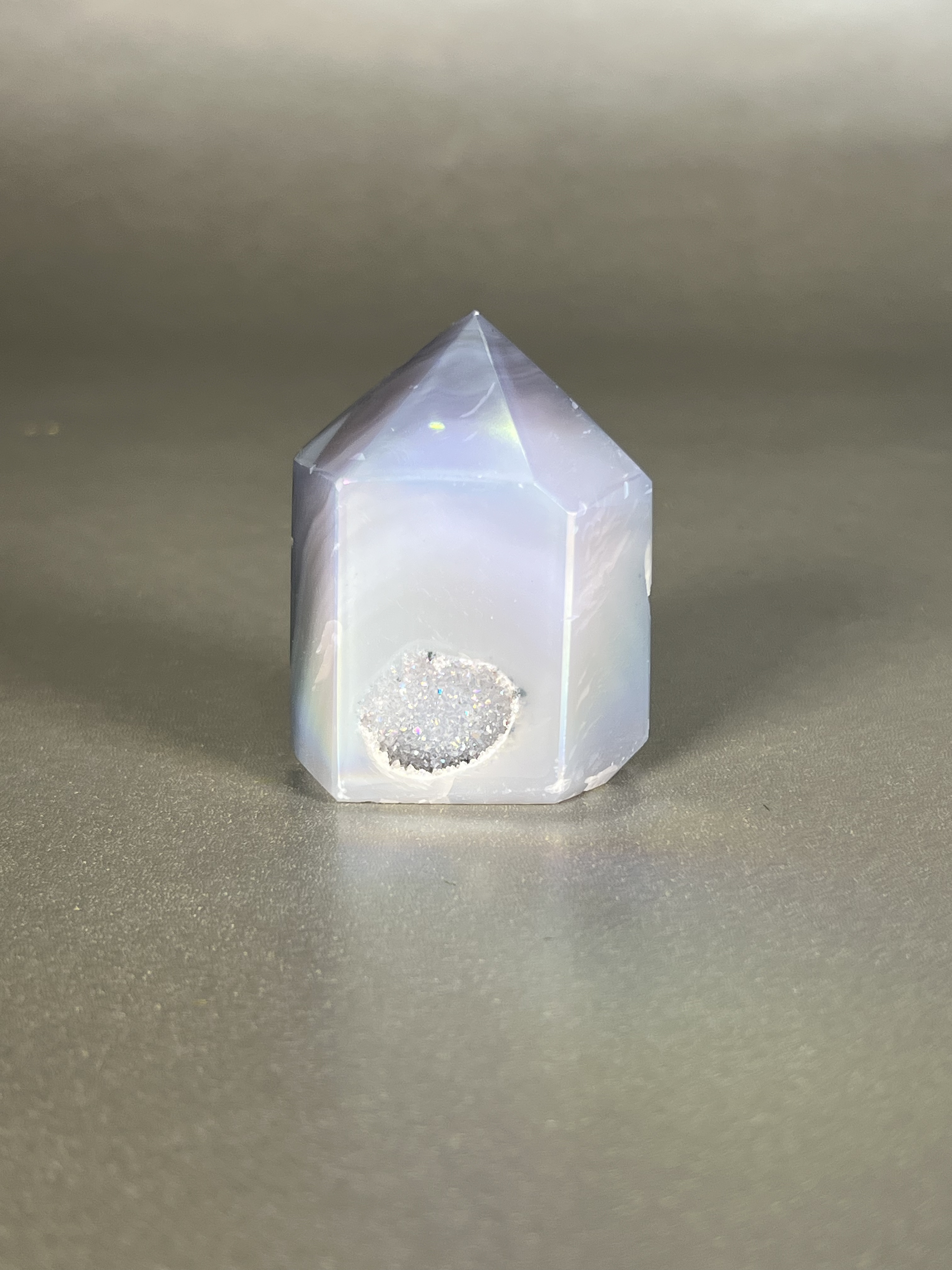 Experience the dreamy elegance of our Aura Agate Obelisk. Each one is uniquely crafted to exude a sense of luxury and exclusivity. Featuring the rare Aura Agate stone, this obelisk brings a touch of sophistication and beauty to any space. Elevate your decor with this truly one-of-a-kind piece. Approx. 1.5" x 2" Aura Agate Tower
