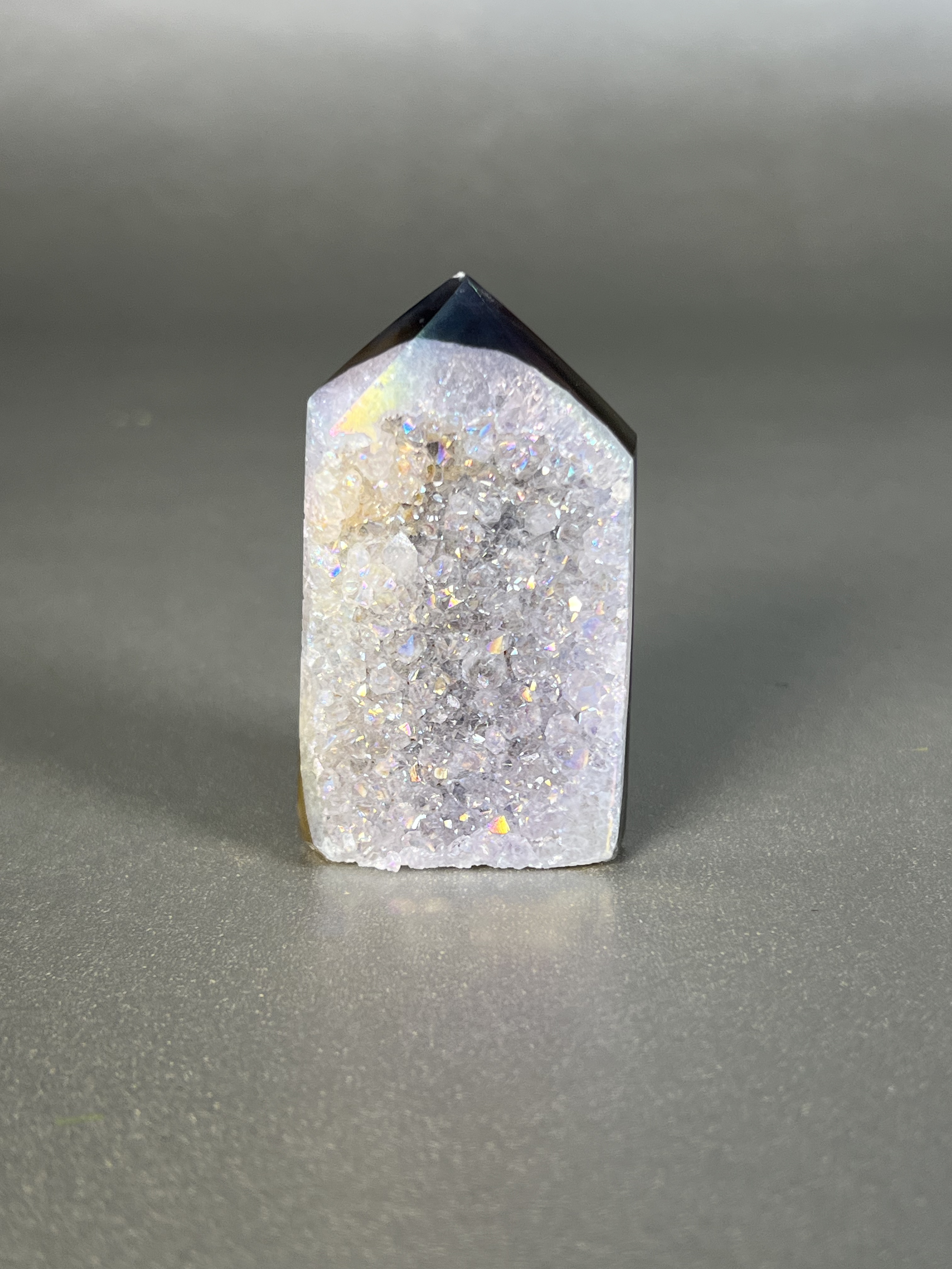 Experience the dreamy elegance of our Aura Agate Obelisk. Each one is uniquely crafted to exude a sense of luxury and exclusivity. Featuring the rare Aura Agate stone, this obelisk brings a touch of sophistication and beauty to any space. Elevate your decor with this truly one-of-a-kind piece. Approx. 1.5" x 2.5" Aura Agate Tower