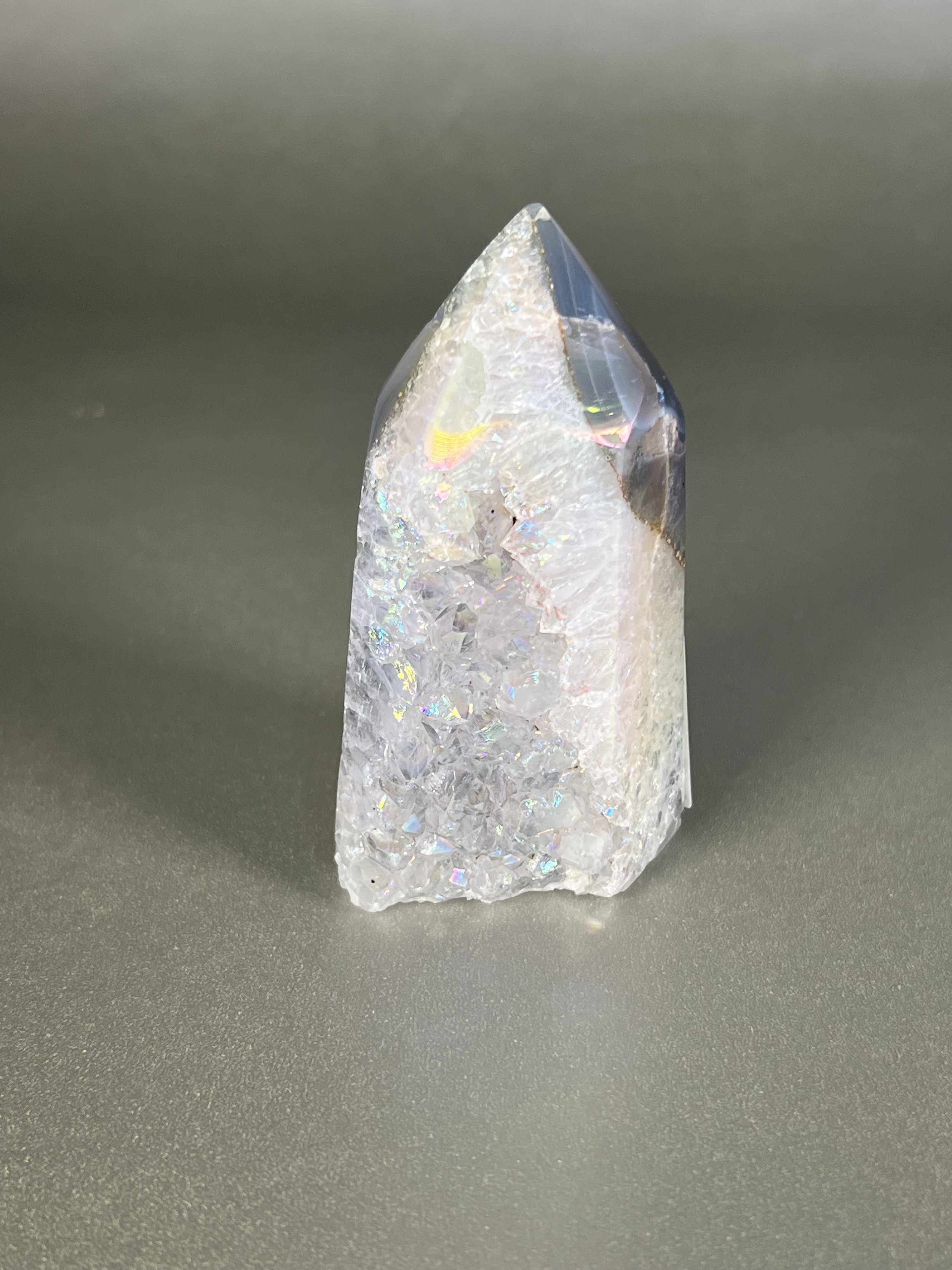 Experience the dreamy elegance of our Aura Agate Obelisk. Each one is uniquely crafted to exude a sense of luxury and exclusivity. Featuring the rare Aura Agate stone, this obelisk brings a touch of sophistication and beauty to any space. Elevate your decor with this truly one-of-a-kind piece. Approx. 2" x 3.5" Aura Agate Tower