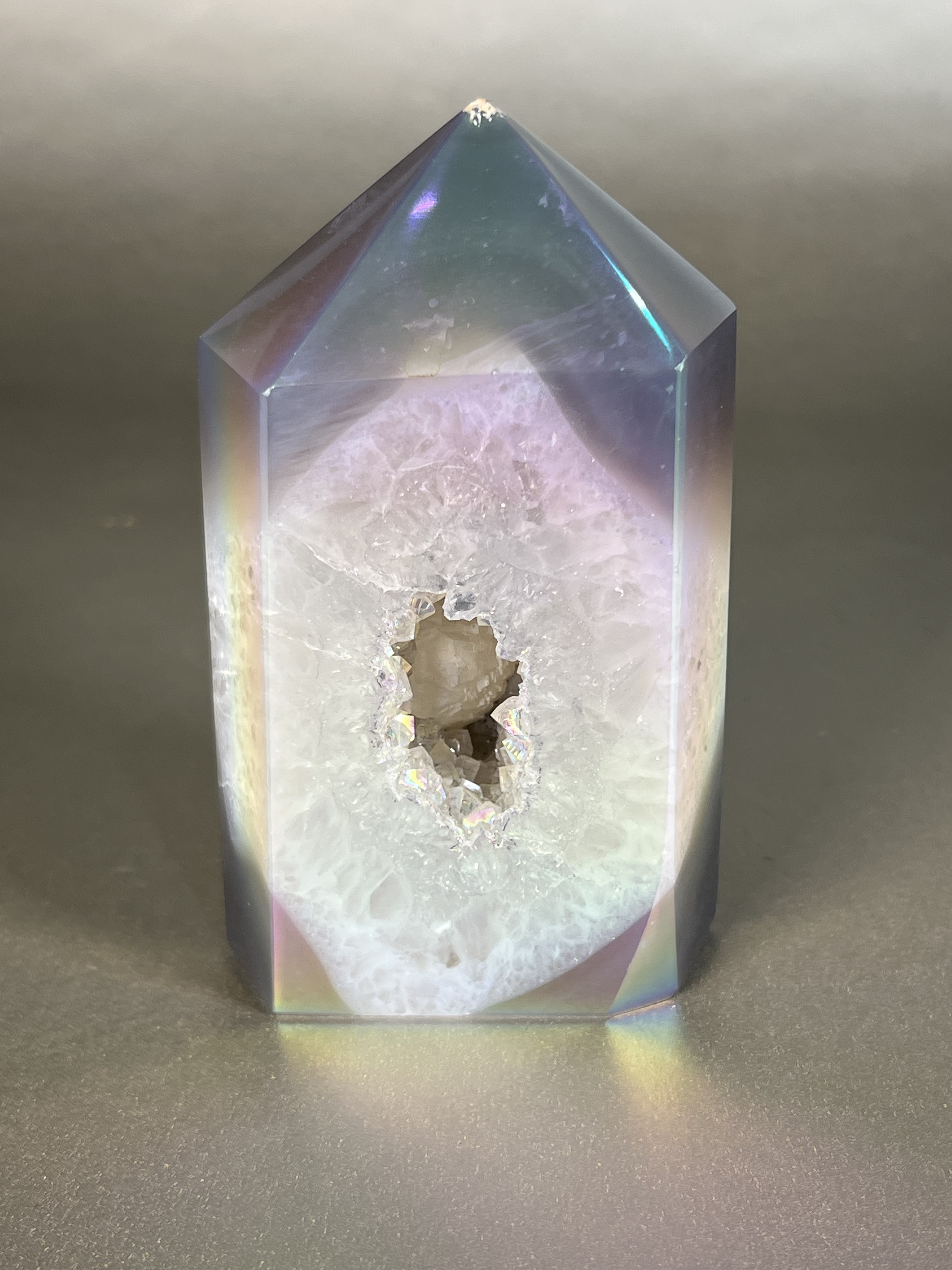 Experience the dreamy elegance of our Aura Agate Obelisk. Each one is uniquely crafted to exude a sense of luxury and exclusivity. Featuring the rare Aura Agate stone, this obelisk brings a touch of sophistication and beauty to any space. Elevate your decor with this truly one-of-a-kind piece. Approx. 3.5"x5" Aura Agate Tower