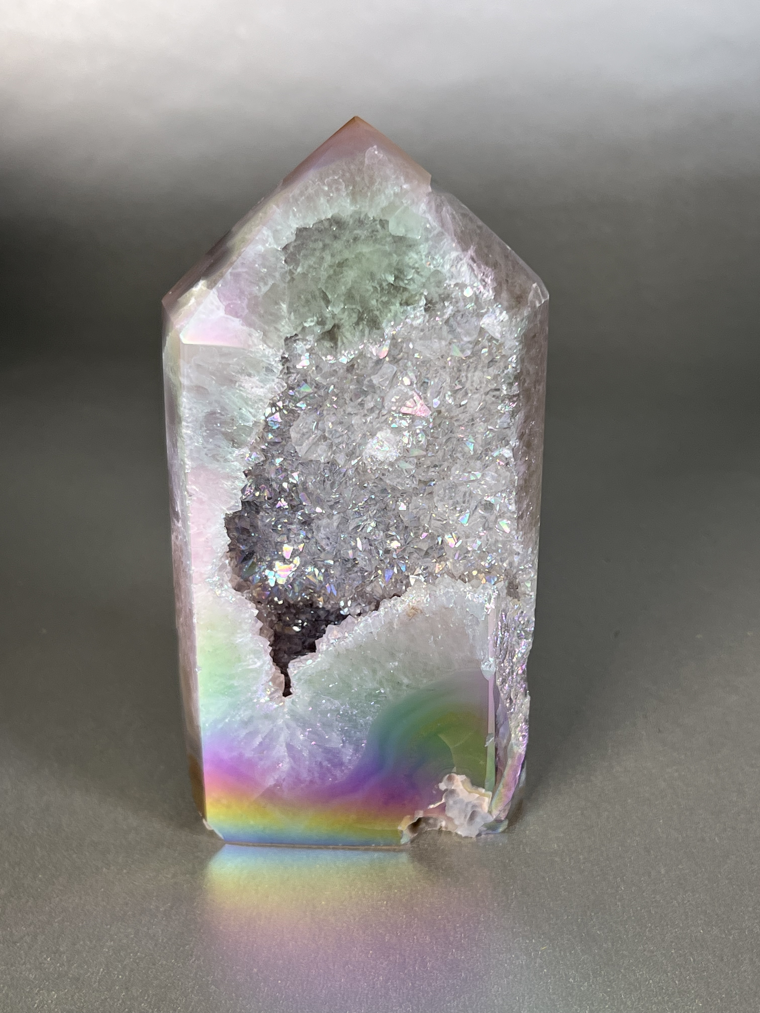 Experience the dreamy elegance of our Aura Agate Obelisk. Each one is uniquely crafted to exude a sense of luxury and exclusivity. Featuring the rare Aura Agate stone, this obelisk brings a touch of sophistication and beauty to any space. Elevate your decor with this truly one-of-a-kind piece. Approx. 3"x6" Aura Agate Tower