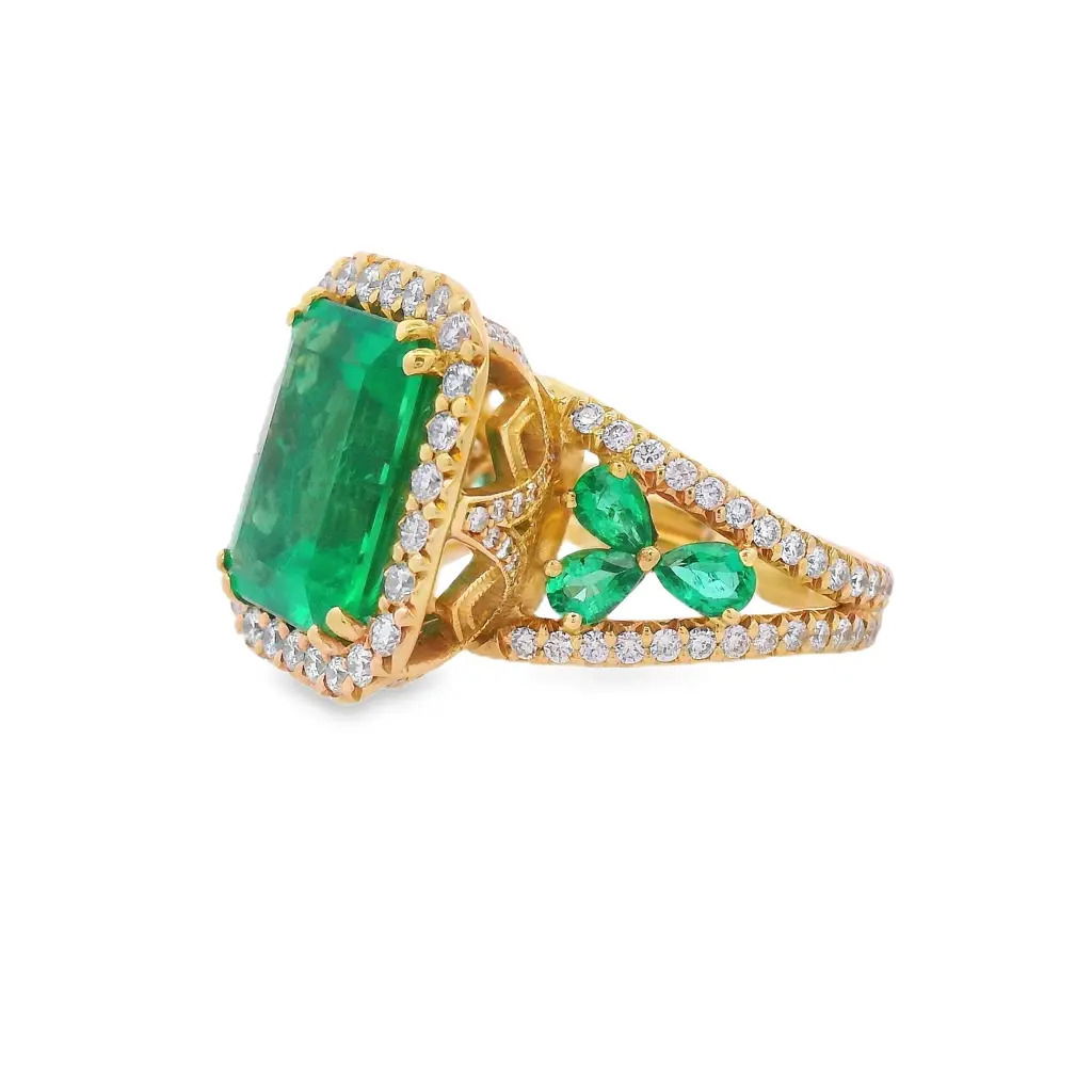 Bold and sophisticated, this ring showcases a stunning 6.19-carat emerald set in rich 18k yellow gold. Framed by a 1.71-carat halo of brilliant diamonds, it delivers exceptional color and sparkle—an eye-catching statement of timeless elegance.-18k Yellow gold -Zambian emerald, 6.19cts -Round diamonds, G-H/VS 1.71cts -Size 7Item# 200-2000144 Page Ring