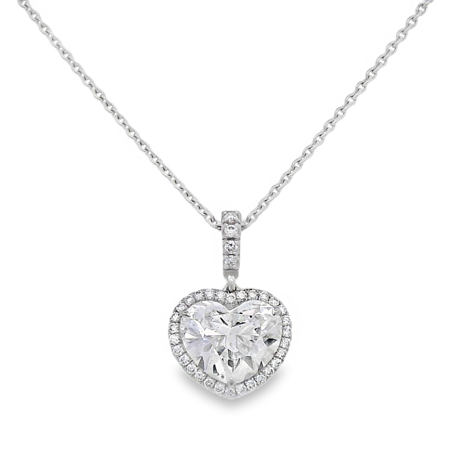 This stunning 18K white gold heart-shaped diamond pendant is a perfect symbol of love and elegance. Crafted with a brilliant centerpiece and surrounded by sparkling stones, it adds a touch of glamour to any outfit. Ideal for special occasions or as a heartfelt gift, this piece is sure to be cherished.-18k White gold-Heart shaped diamond, 2.03cts-Round diamonds, 0.19cts-Length, 18" Item# 160-2000022 Heart Shaped Pendant