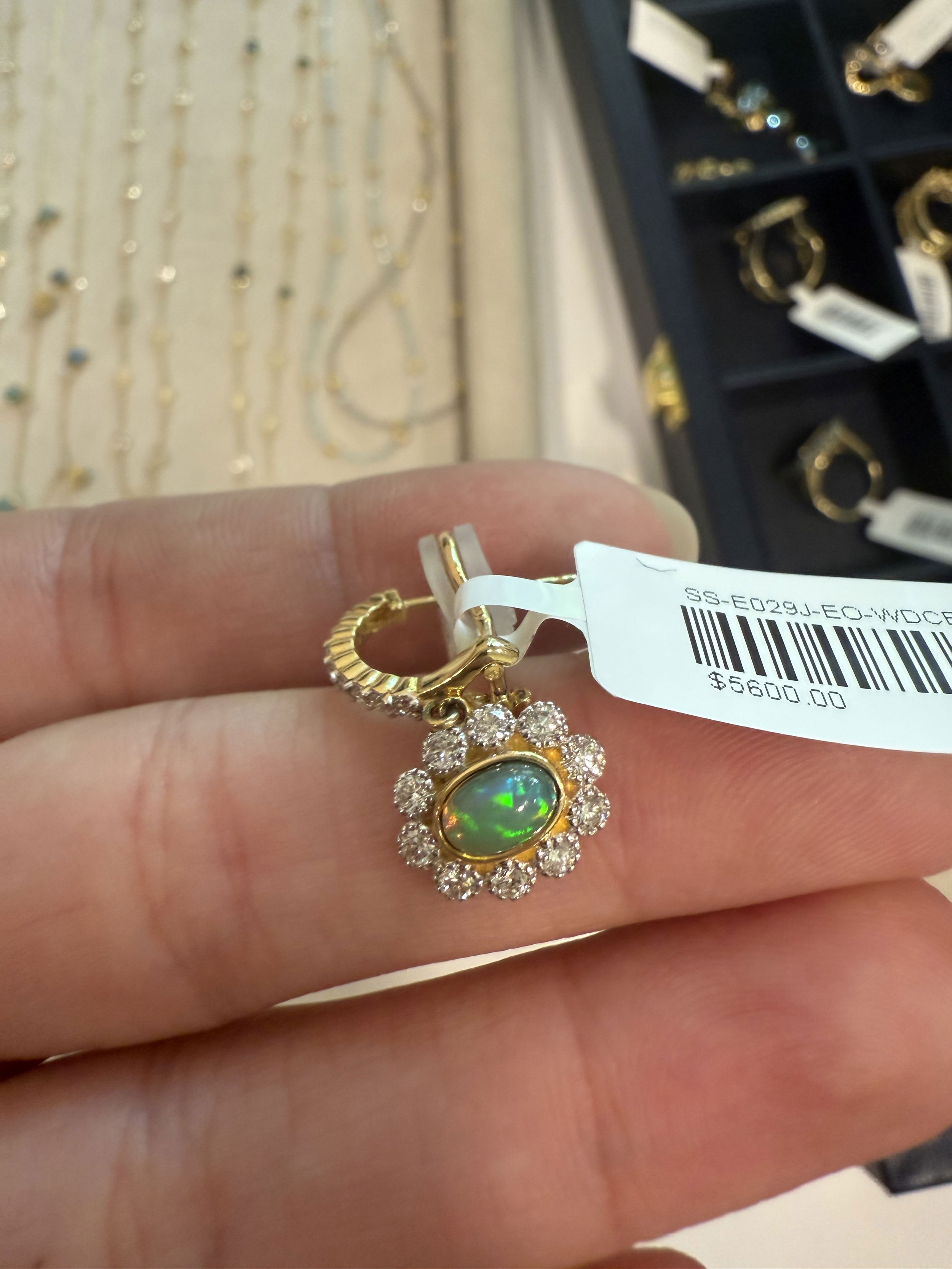 Each earring features a mesmerizing opal, radiating iridescent hues, gracefully suspended beneath a sparkling array of brilliant-cut diamonds. Perfect for special occasions or a touch of everyday luxury, these earrings are a timeless addition to any jewelry collection.18k Yellow gold-Ethiopian opals, 0.90cts-Round diamonds, 0.82ctsItem# 805-2000539 Opal and Diamond Drop Earrings