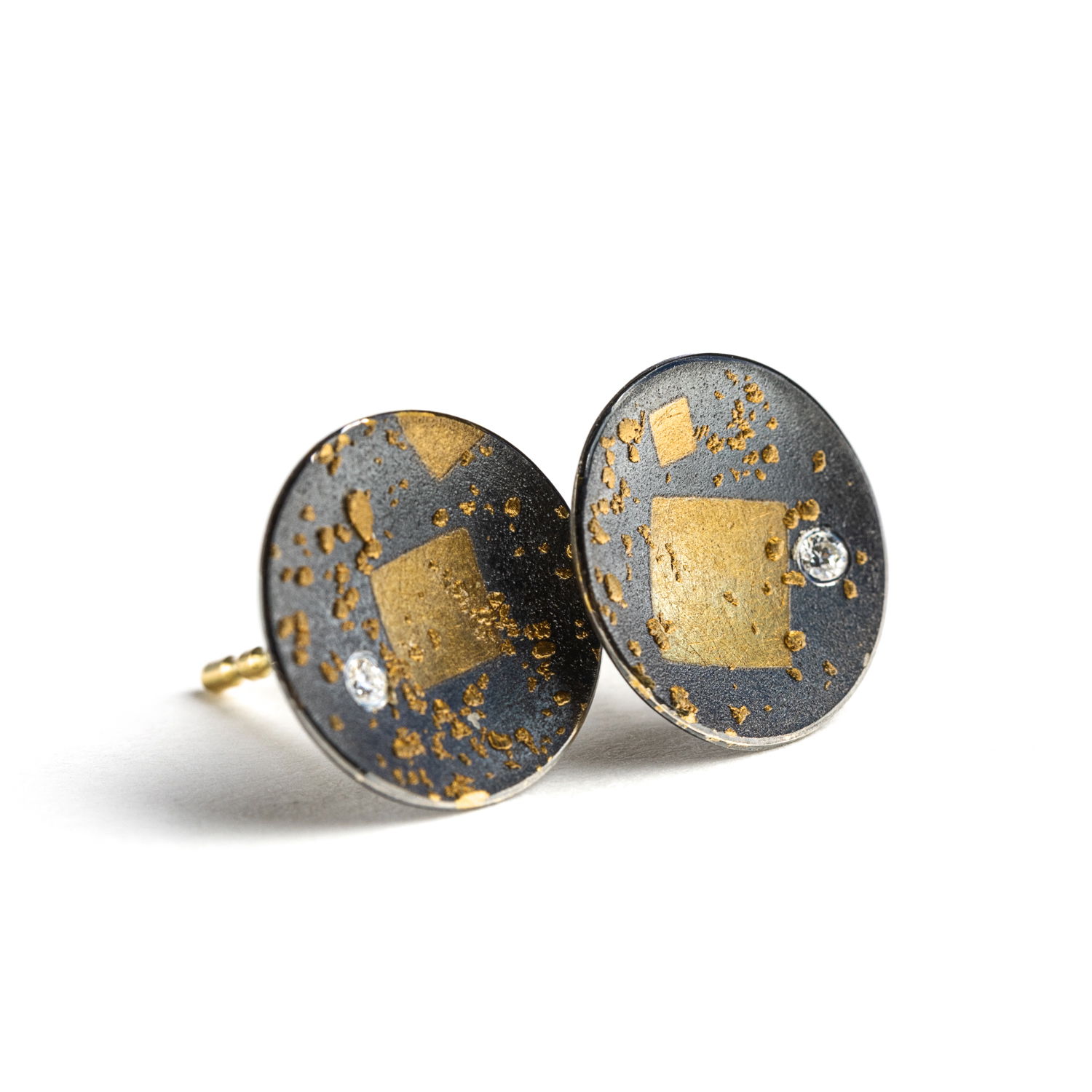 Understated with an edge, these Zobel disc studs feature scattered gold leaf and a single diamond set against matte oxidized silver. Artful in texture and form, they’re your go-to for everyday distinction.-Sterling silver & 24k yellow gold-Round diamonds, 0.02ctsItem# 805-2000566 Disc Studs