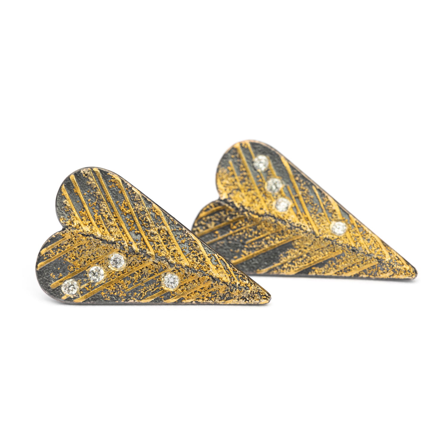 These elongated heart studs are crafted in oxidized sterling silver, brushed with rich 24k gold and accented by a scattering of white diamonds. Bold yet tender, their textured finish and unexpected shape bring a modern edge to a timeless symbol. Love, reimagined. -Sterling Silver & 24k yellow gold-Round diamonds, 0.04ctsItem# 805-2000567 Long Heart Studs