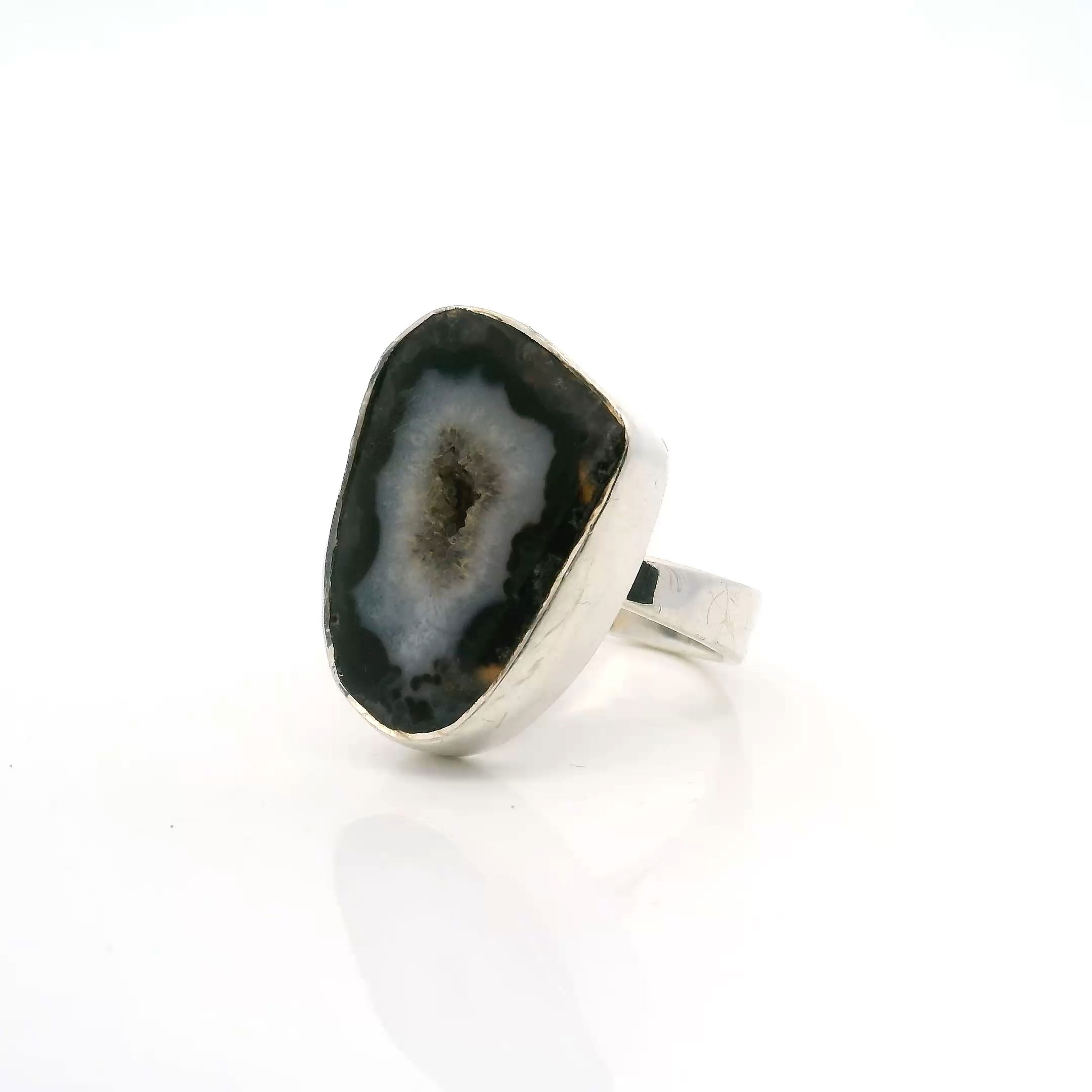 Illuminate your style with this striking Natural Agate Druze Geode Ring, masterfully set in 925 Sterling Silver. Showcasing a mesmerizing gray druze center, this adjustable gemstone ring boasts an organic agate geode with a radiant white outline, revealing a sparkling bed of natural quartz crystals. Each handcrafted ring is a unique statement piece, blending earthy elegance with modern sophistication—perfect for elevating your everyday look or adding an artful accent to any special occasion. Natural Agate Druze Geode Ring With White Outline & Quartz & Gray Druze Sz ADJ