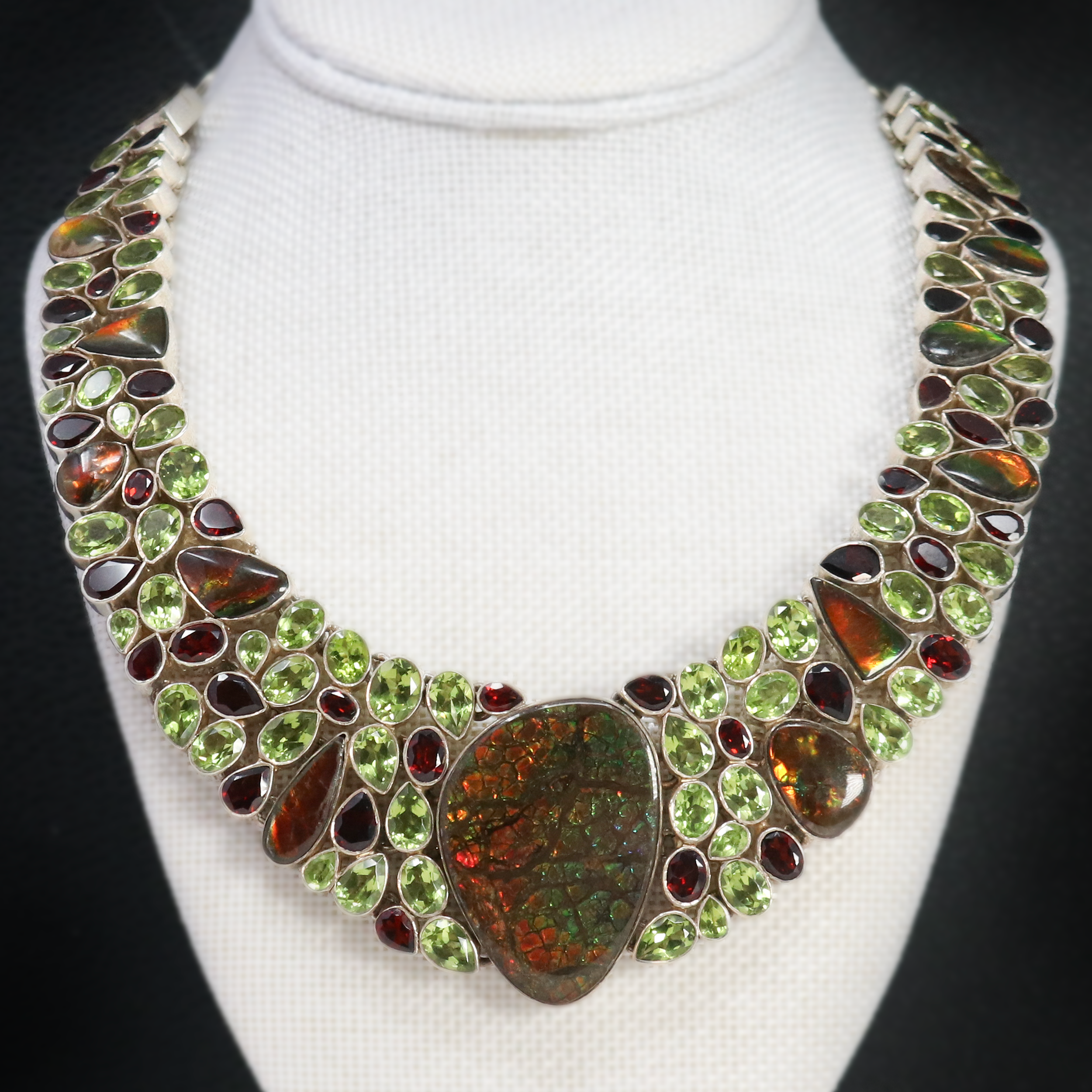 Discover the harmonious blend of nature's rarest treasures with our exquisite Ammolite Fossil & Peridot Necklace Collar. Featuring a stunning array of rainbow-hued Ammolite, vibrant Peridot, and rich Garnet, this piece is a celebration of color and craftsmanship. Ammolite Fossil & Peridot Necklace Collar -Rainbow With Garnet