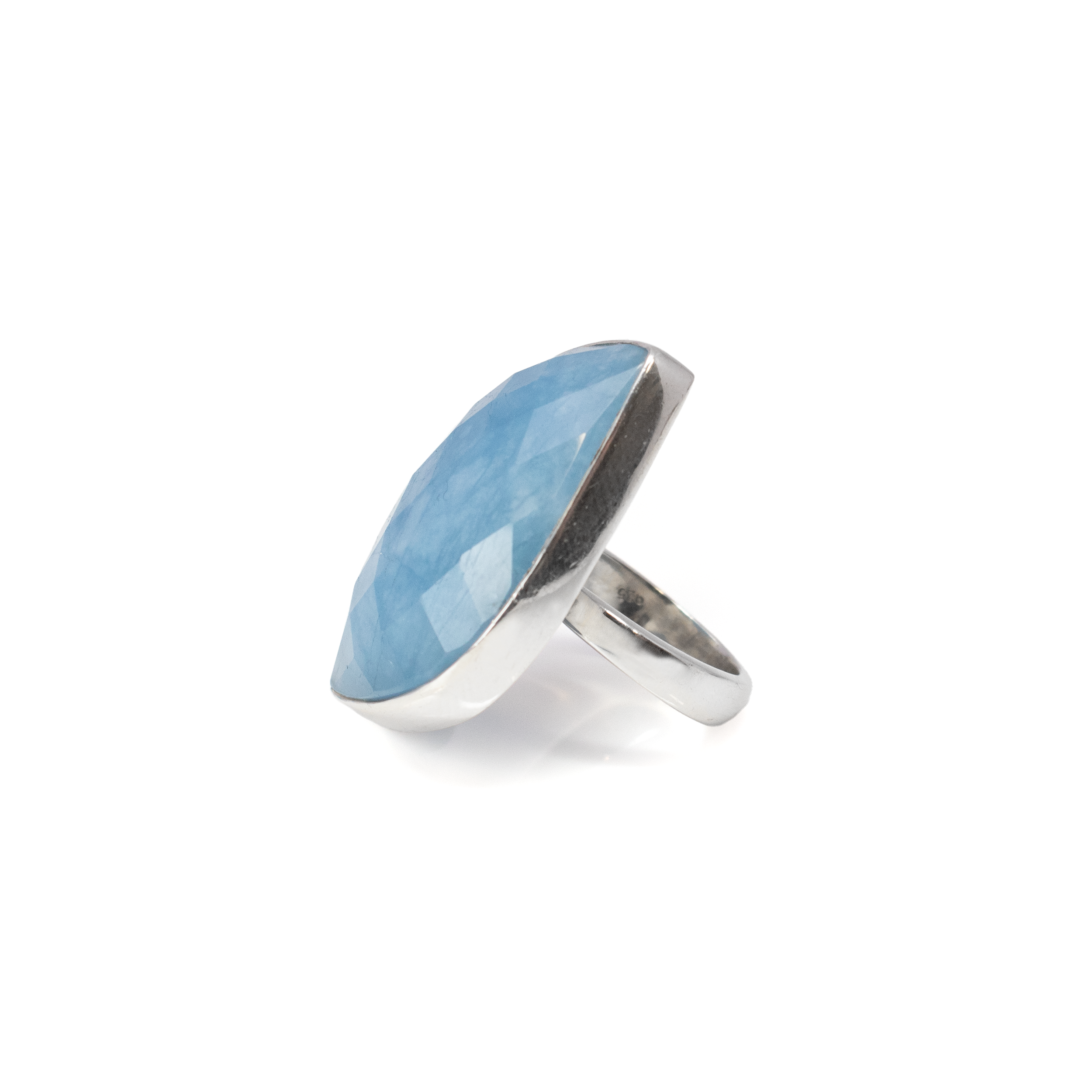 Indulge in the serene elegance of our Aquamarine Ring, a masterpiece from the Rare Earth Gallery's exclusive collection. This exquisite ring features a captivating aquamarine gemstone, expertly faceted into a unique S-shape that captures and reflects light with every movement, revealing the stone’s tranquil and captivating blue hues reminiscent of the ocean depths.Encased in a sleek 925 sterling silver bezel setting, the aquamarine gemstone is showcased in all its glory, providing a modern and sophisticated backdrop that enhances its natural beauty. The sterling silver not only adds a touch of classic elegance but also ensures durability, making this ring a cherished piece for years to come. Aquamarine Ring - Faceted S-shape With Silver Bezel Szadj