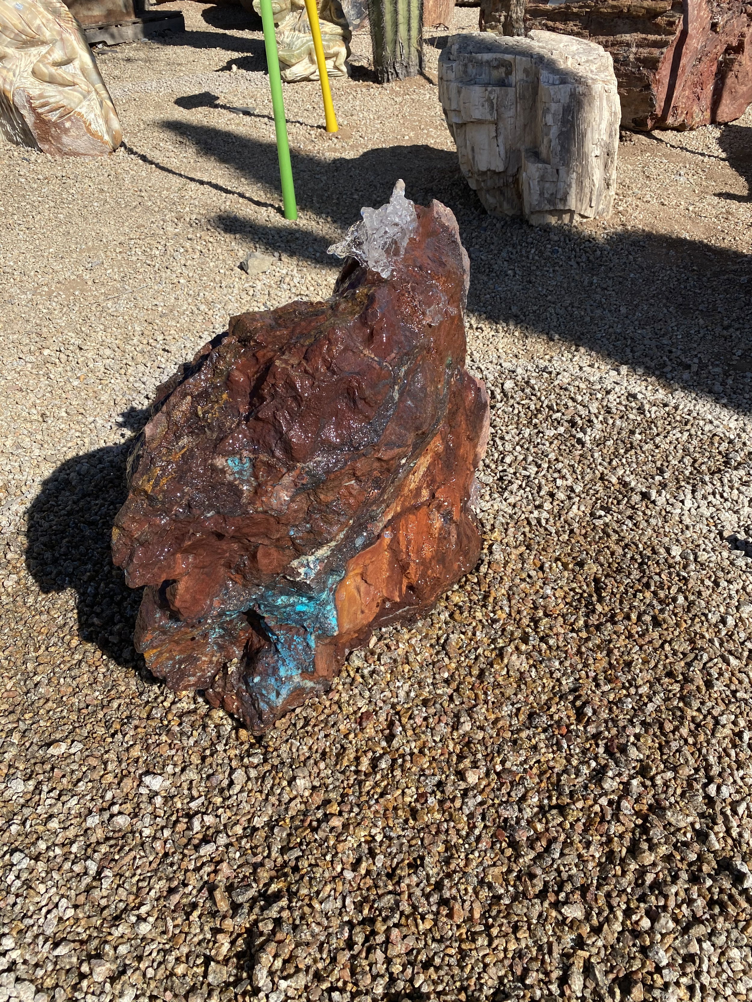 The Arizona Copper Ore Fountain - Moonlight Mine Chrysocolla & Specular Hematite enhances the tranquility of your yard, garden, or patio with its mesmerizing combination of vibrant Chrysocolla and striking Specular Hematite. Its captivating design brings an aesthetic appeal that elevates the overall ambiance of your outdoor space. Let Rare Earth Gallery’s white-glove service make your fountain dreams come true—simply choose your fountain, tell us where it goes, and we’ll handle the rest, from delivery to installation. IMPORTANT: the purchase price listed is for the FOUNTAIN ONLY and DOES NOT INCLUDE the cost of a basin, pump, parts or installation. Before purchasing a fountain online, we STRONGLY recommend you call us at (480) 575-4360 for a FREE consultation to discuss these additional costs and schedule a pre-site inspection. Also, free shipping does NOT apply to fountains, please call for a quote. Arizona Copper Ore Fountain - Moonlight Mine Chrysocolla & Specular Hematite