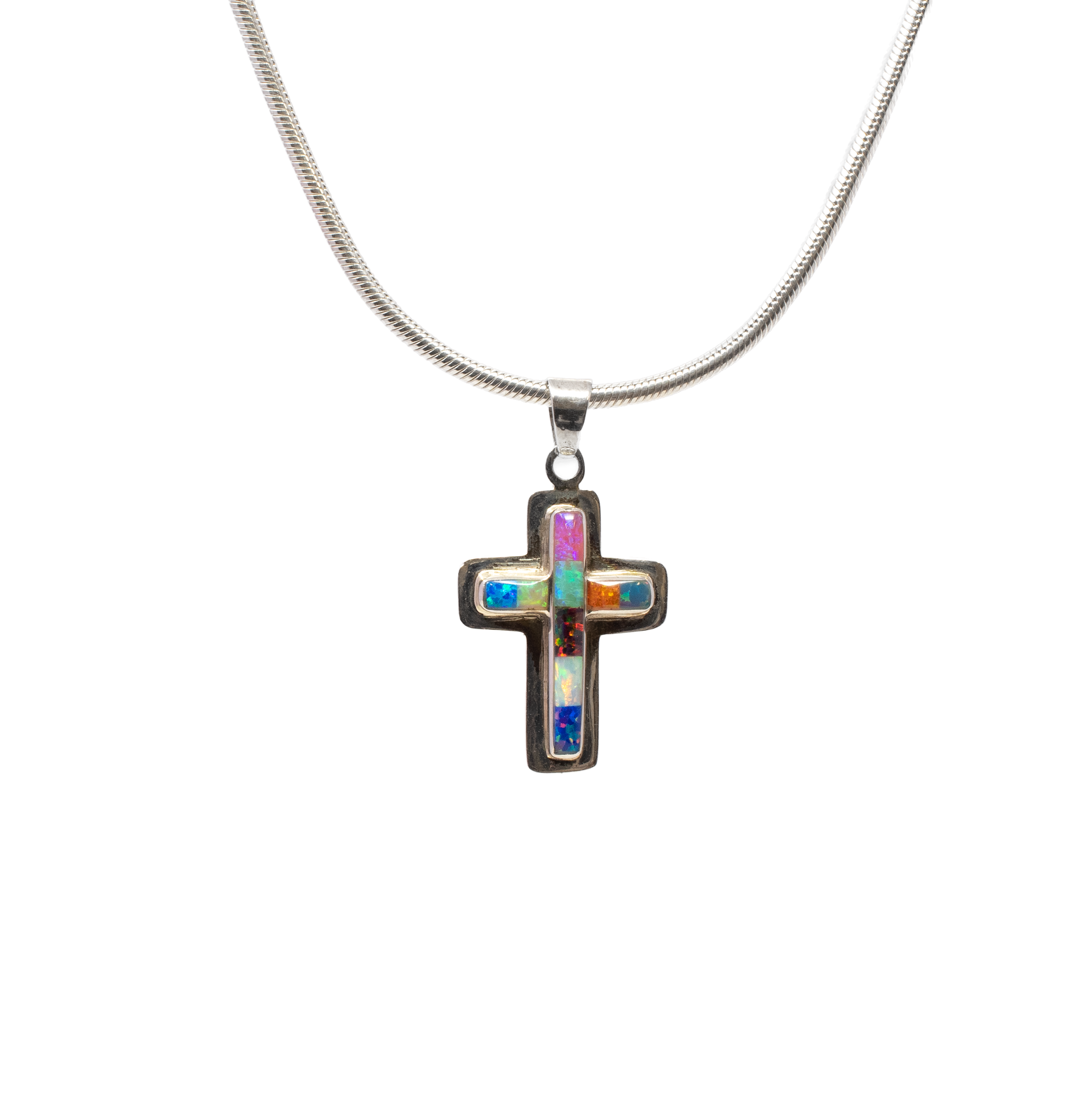 Introducing our stunning Multi Fire Opal Inlay Cross Pendant, a captivating piece that perfectly blends elegance with spirituality. This exquisite pendant features a simple yet sophisticated cross design, meticulously crafted with a sleek silver bezel edge. The highlight of this pendant is the mesmerizing multicolor rectangular inlay of fire opals, each meticulously chosen for its vibrant play of colors.The fire opals, known for their radiant flashes of fiery reds, oranges, blues, and greens, create an eye-catching tapestry of colors that symbolize hope, faith, and renewal. Each opal is expertly inlaid to ensure a seamless fit and a smooth finish, accentuating the natural beauty of these captivating gems. Multi Fire Opal Inlay Cross Pendant - Simple Cross With Silver Bezel Edge & Multicolor Rectangular Inlay