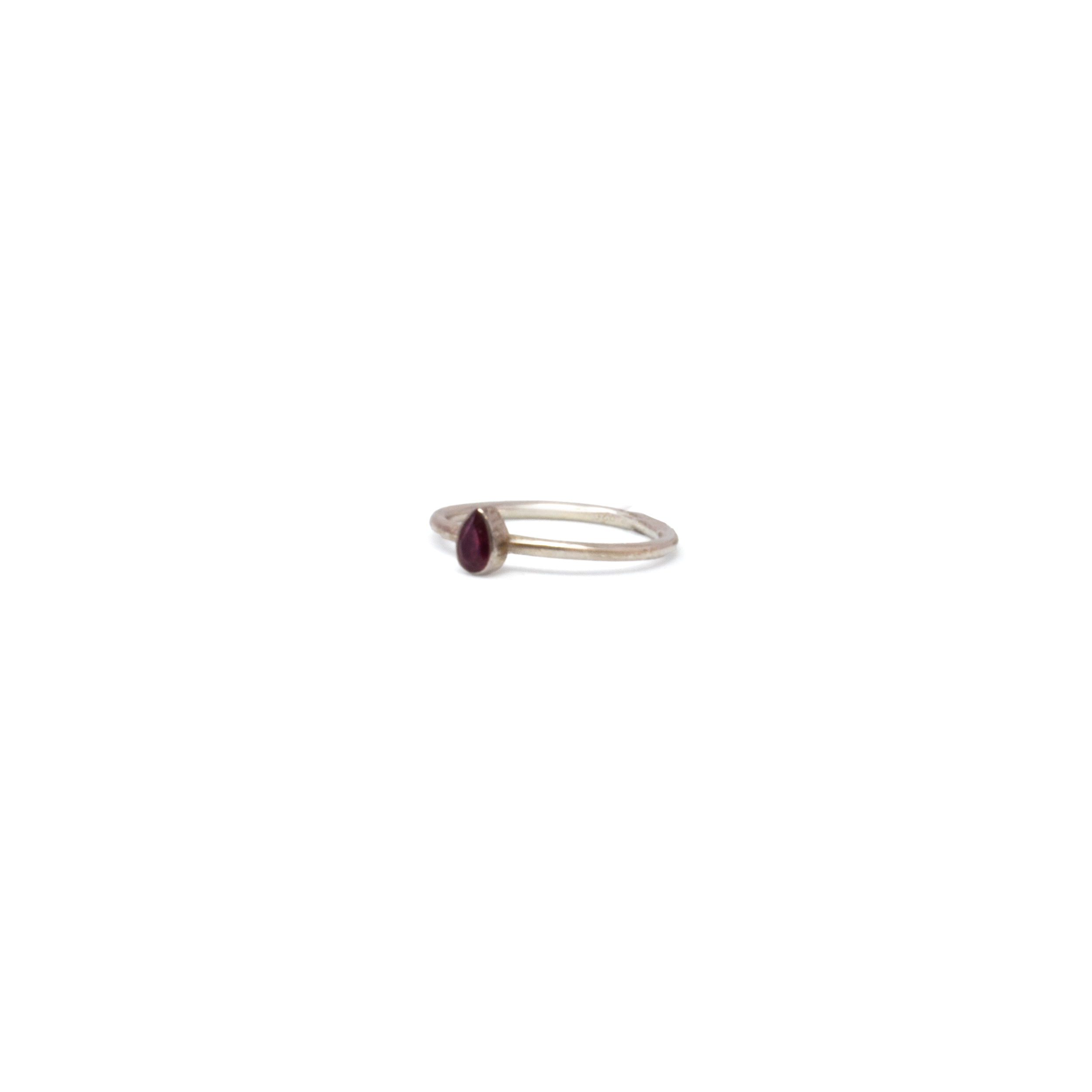 This Faceted Pear-Cut Ruby Ring in 925 sterling silver captures timeless elegance in a minimalist form. Sized at 7, the vibrant pear-shaped ruby is bezel-set to highlight its natural brilliance, while the polished silver band offers enduring shine and comfort. A refined accent for everyday wear or special occasions, this piece adds a graceful touch of color and classic charm to any collection. Ruby Ring - Dainty Faceted Pear With Silver Bezel Sz7