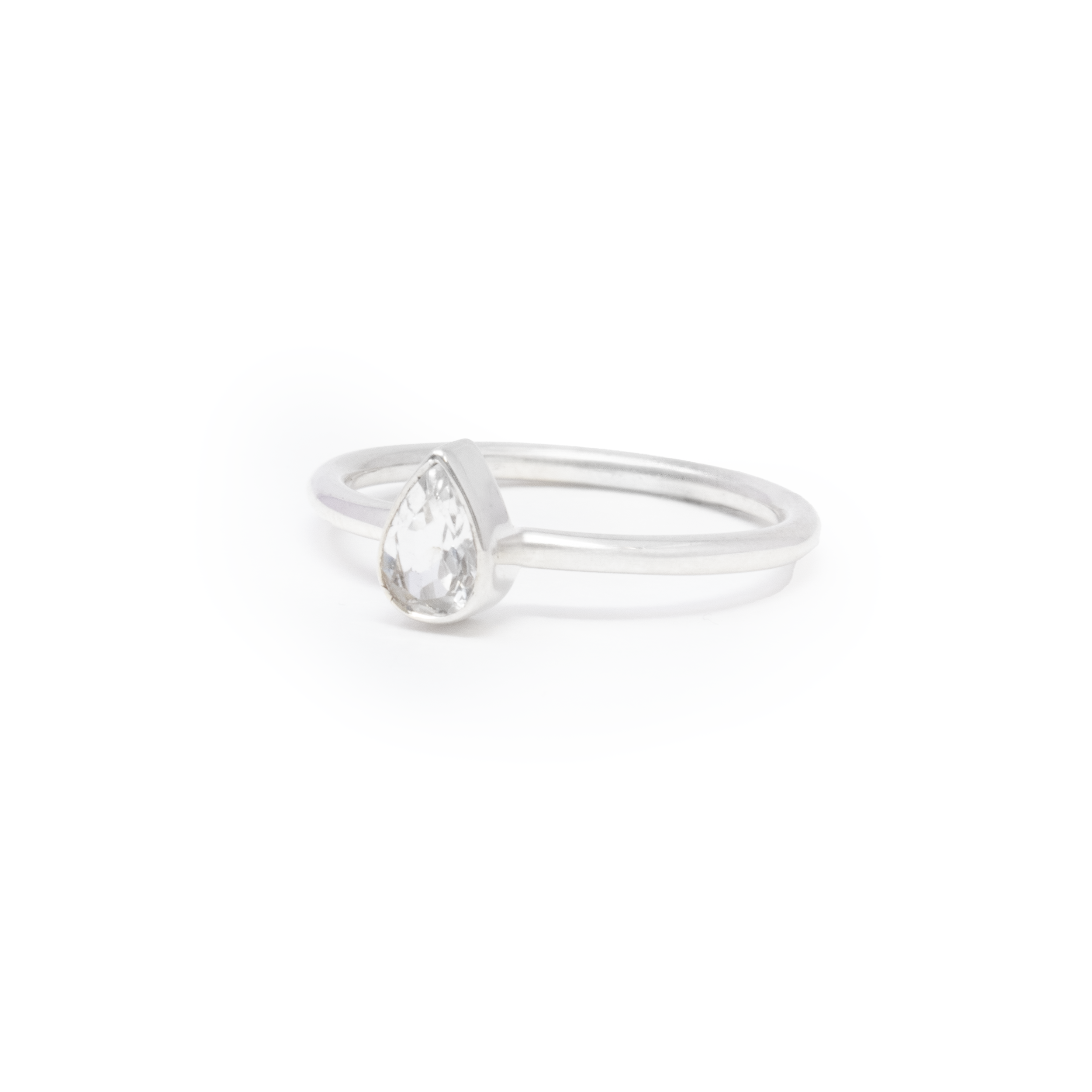 Introducing our exquisite White Topaz Ring, a beautifully crafted piece that embodies elegance and sophistication. This dainty ring features a stunning, faceted pear-shaped white topaz gemstone, known for its captivating clarity and brilliance. The gem is thoughtfully set in a simple yet elegant silver bezel, allowing its natural beauty to take center stage.Made with 925 sterling silver, this ring offers durability and a timeless appeal, ensuring it remains a cherished piece in your jewelry collection for years to come. The minimalist design makes it versatile enough for everyday wear, while its striking sparkle ensures it stands out for special occasions. This ring can not be sized. White Topaz Ring - Dainty Faceted Pear With Simple Silver Bezel Sz7