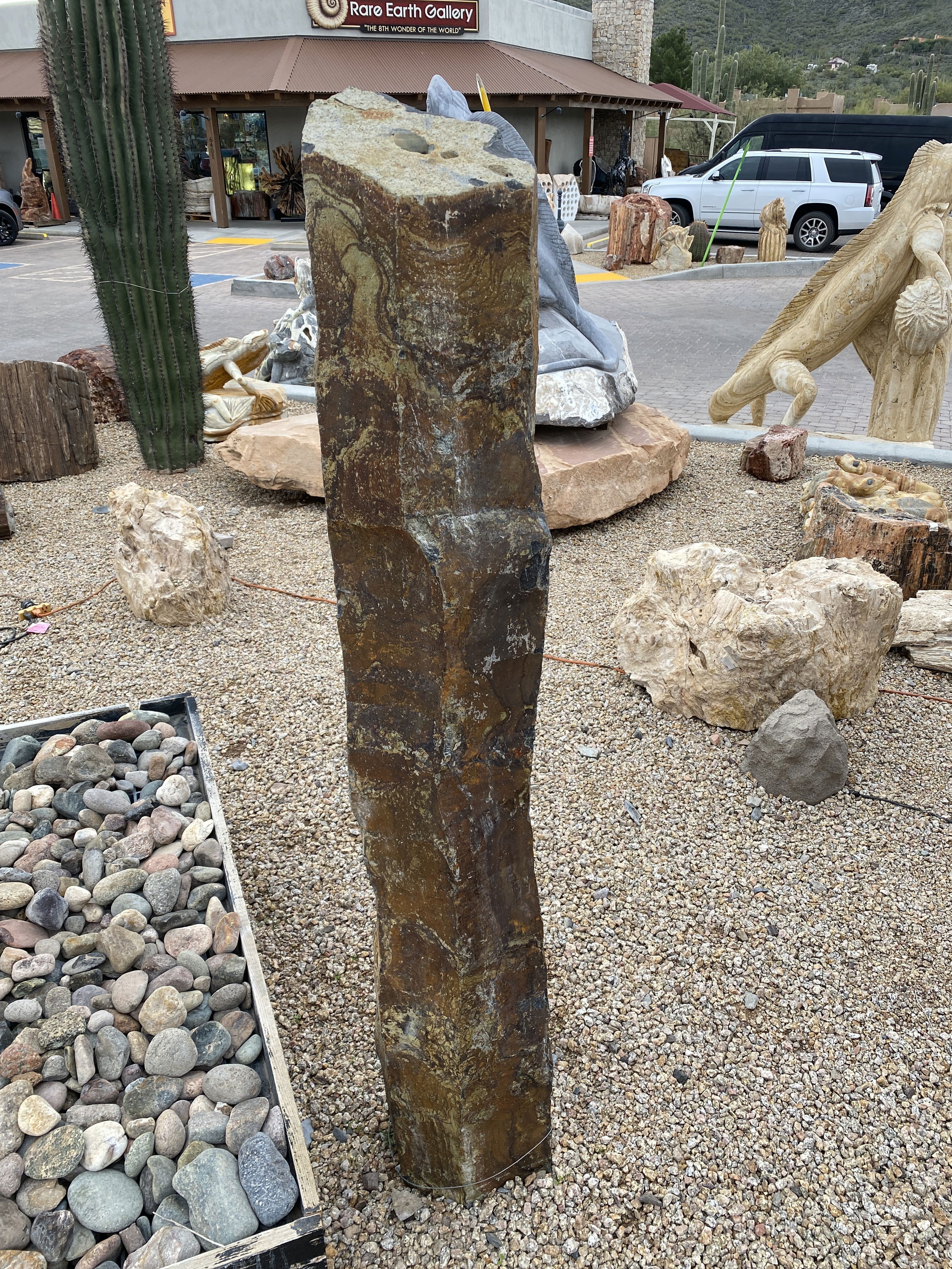 The Gold Creek Basalt Column 5' Fountain is a visually stunning addition for your yard, garden, or patio that brings tranquility and enhances the aesthetics of any space. Crafted from premium basalt, this fountain exudes a sense of natural beauty, creating a serene ambiance for relaxation and enjoyment. Let Rare Earth Gallery’s white-glove service make your fountain dreams come true—simply choose your fountain, tell us where it goes, and we’ll handle the rest, from delivery to installation. IMPORTANT: the purchase price listed is for the FOUNTAIN ONLY and DOES NOT INCLUDE the cost of a basin, pump, parts or installation. Before purchasing a fountain online, we STRONGLY recommend you call us at (480) 575-4360 for a FREE consultation to discuss these additional costs and schedule a pre-site inspection. Also, free shipping does NOT apply to fountains, please call for a quote. Gold Creek Basalt Column 5' Fountain