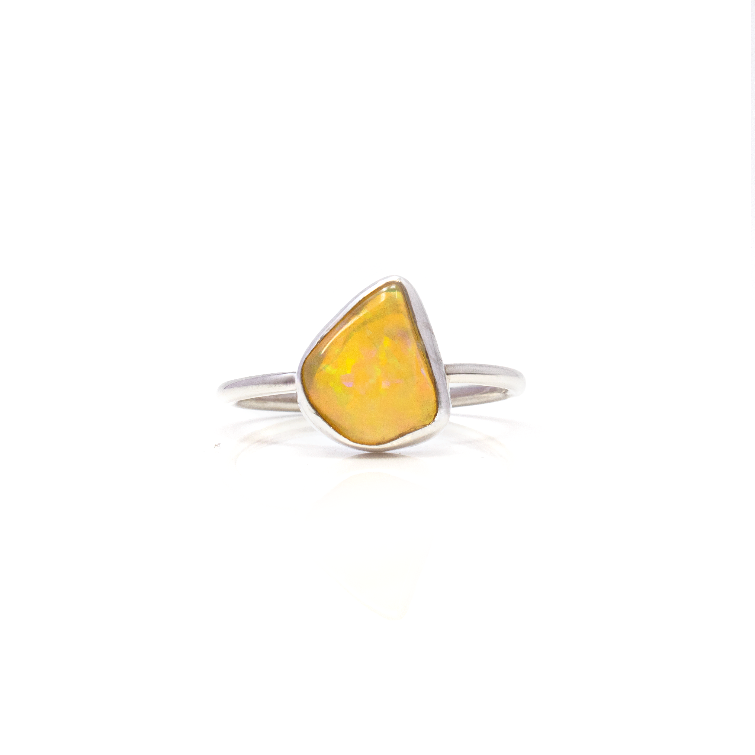 Elevate your jewelry collection with the mesmerizing beauty of our Ethiopian Opal Ring, featuring an exquisite angular nugget design that captivates the eye. This stunning piece showcases the natural allure of Ethiopian Opal, renowned for its vibrant play-of-color, which dances brilliantly with every movement.Encased in a refined 925 sterling silver bezel setting, the opal's iridescence is beautifully complemented by the ring's sleek and modern silhouette. The high-quality silver enhances the gemstone’s radiance while providing a durable and timeless frame that promises longevity and elegance. Ethiopian Opal Ring - Angular Nugget With Silver Bezel Sz8