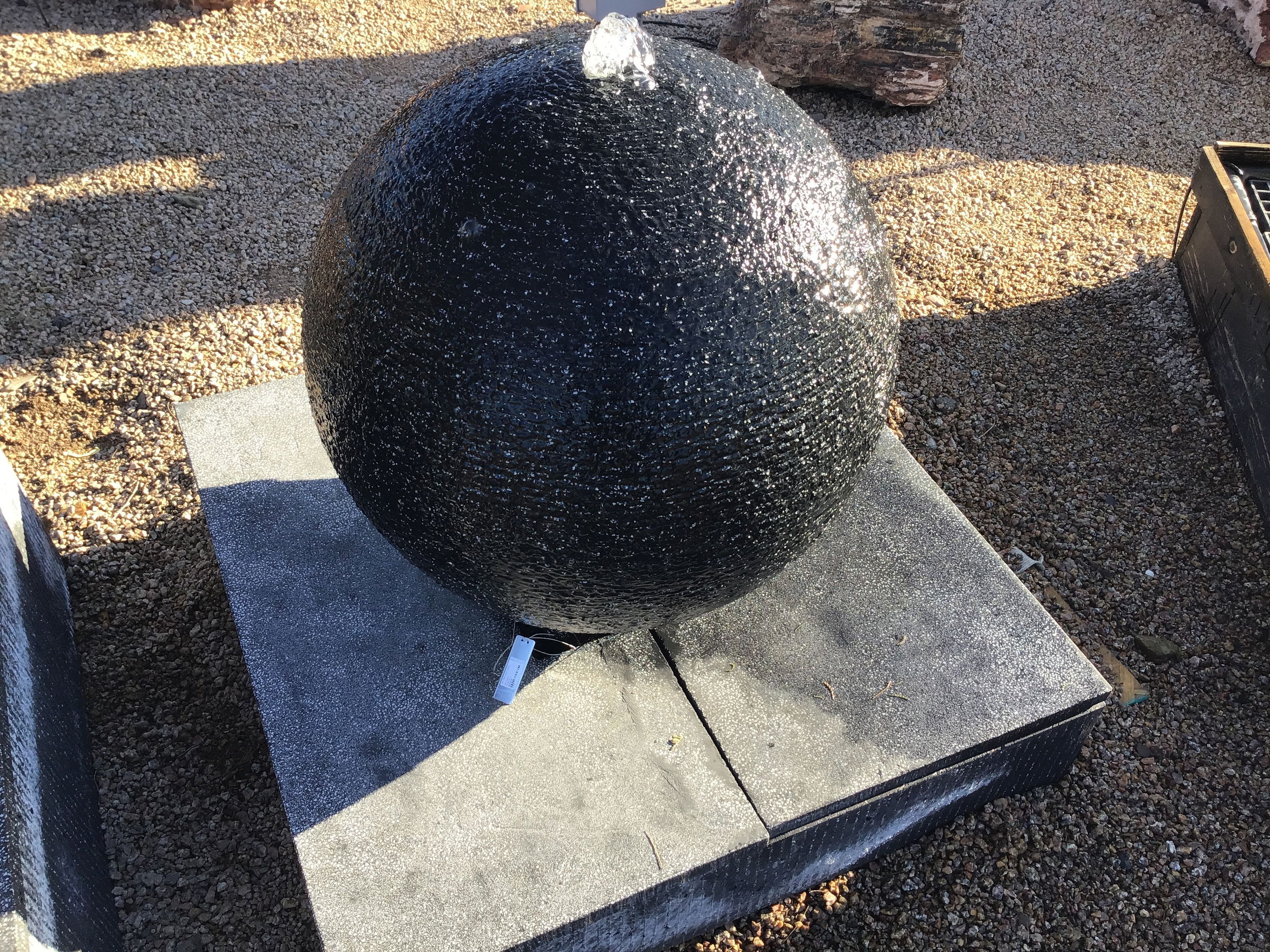 The 28" Diameter Black Cast Concrete Sphere Fountain - Small creates a serene atmosphere in any outdoor space, bringing tranquility and enhancing the visual appeal of your yard, garden, or patio. Its elegant design and soothing water flow make it a perfect addition to create a peaceful oasis. Let Rare Earth Gallery’s white-glove service make your fountain dreams come true—simply choose your fountain, tell us where it goes, and we’ll handle the rest, from delivery to installation. IMPORTANT: the purchase price listed is for the FOUNTAIN ONLY and DOES NOT INCLUDE the cost of a pump, parts or installation. Before purchasing a fountain online, we STRONGLY recommend you call us at (480) 575-4360 for a FREE consultation to discuss these additional costs and schedule a pre-site inspection. Also, free shipping does NOT apply to fountains, please call for a quote. 28" Diameter Black Cast Concrete Sphere Fountain - Small
