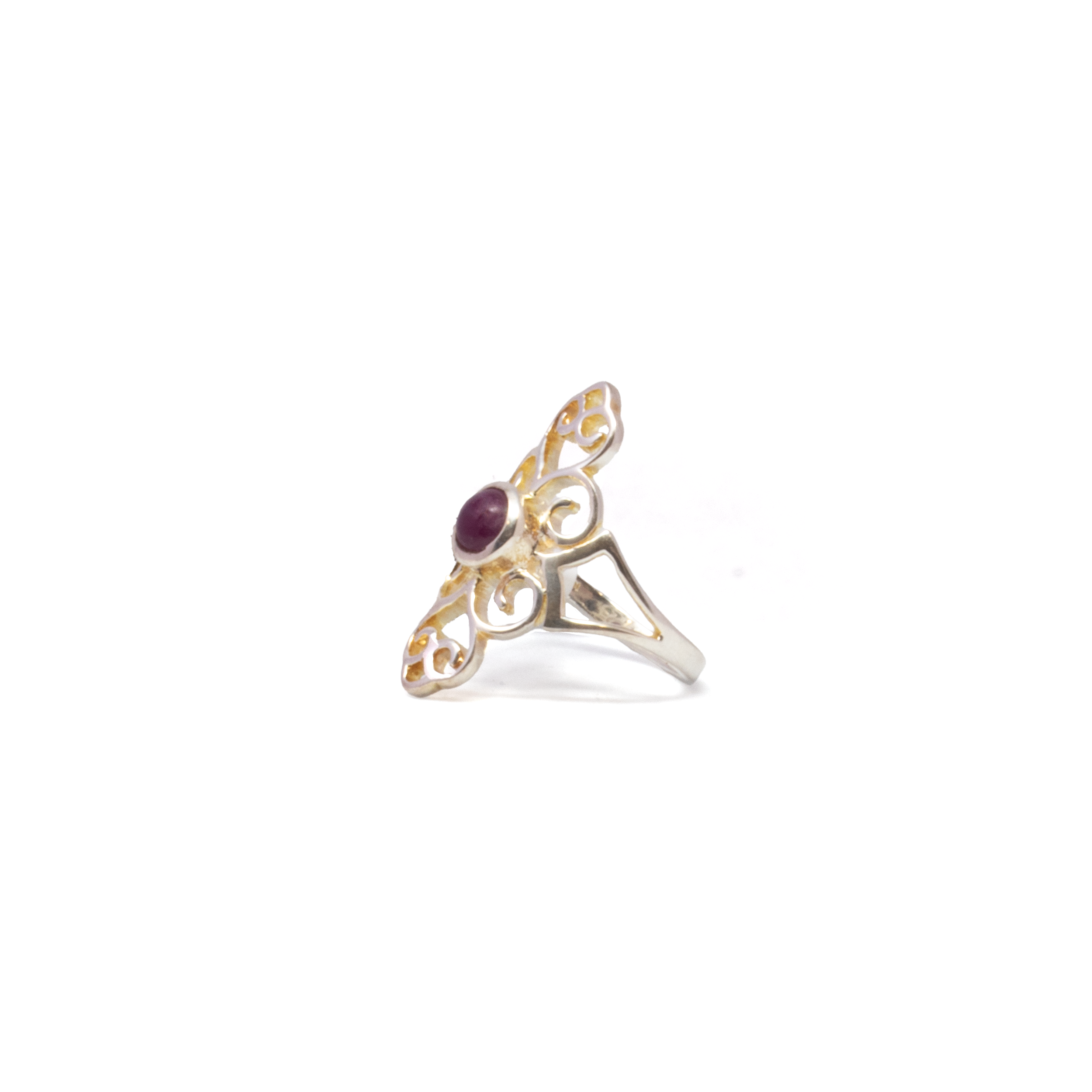 A smooth round cabochon ruby glows at the center of this elegant ring, bezel set in polished 925 sterling silver. The open filigree band adds vintage-inspired refinement, with intricate metalwork that elevates the deep red gemstone's natural warmth. Sized at 9, this piece combines old-world charm with enduring craftsmanship—a bold yet graceful addition to any jewelry collection. Ruby Ring - Round Cabochon With 925 Sterling Silver Bezel On Ornate Open Filigree Band Sz9