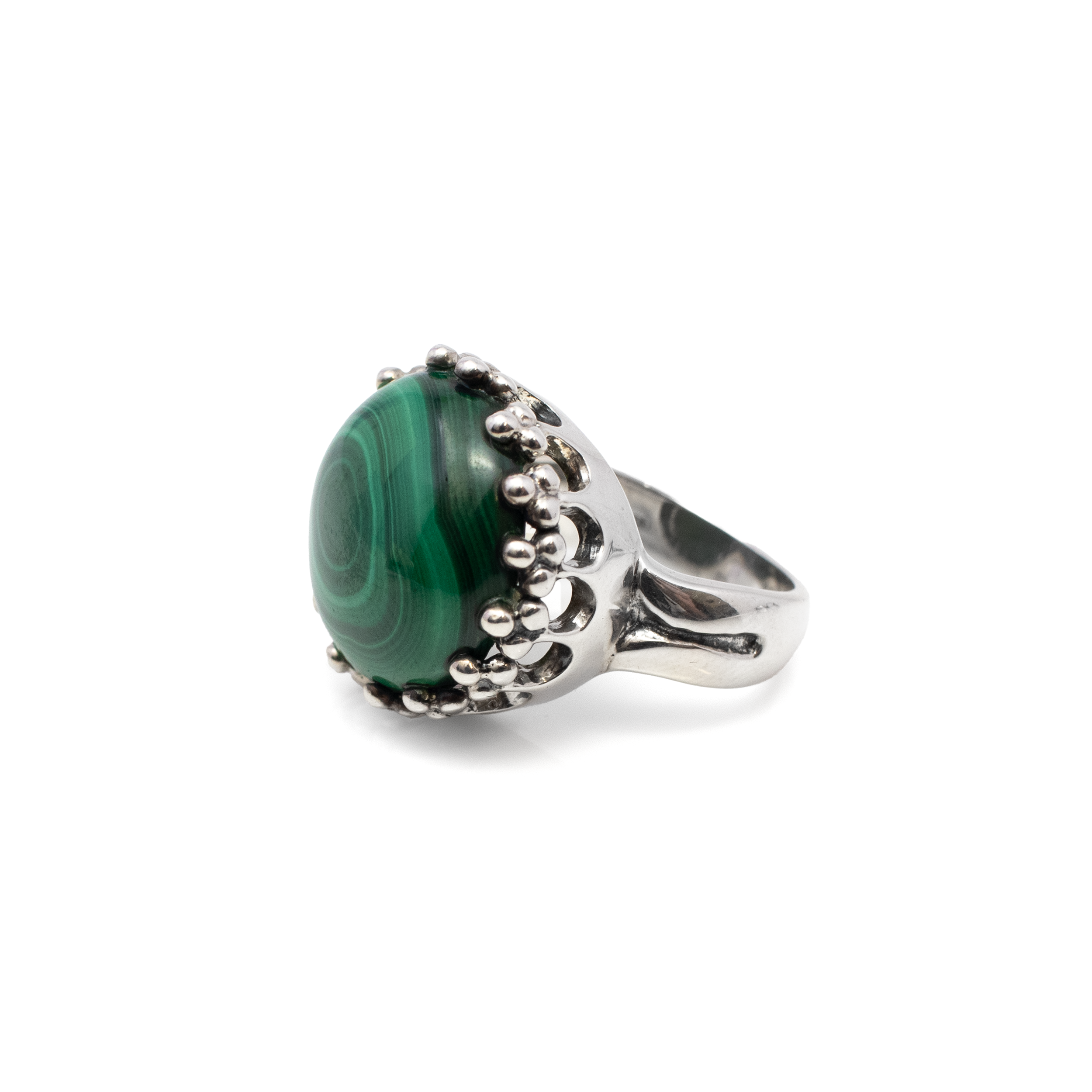 Introducing our exquisite Malachite Ring, a stunning addition to any jewelry collection. Crafted with meticulous attention to detail, this ring features a mesmerizing round malachite cabochon, renowned for its rich green hues and unique, swirling patterns. Each stone is distinctive, making every ring a one-of-a-kind masterpiece.The malachite gemstone is elegantly set in a 925 sterling silver crown bezel, enhancing its natural beauty while ensuring durability and comfort. The intricate crown setting adds a touch of regal elegance, making it an excellent choice for both everyday wear and special occasions. Malachite Ring - Round Cabochon Set In 925 Sterling Silver Crown Bezel Sz8