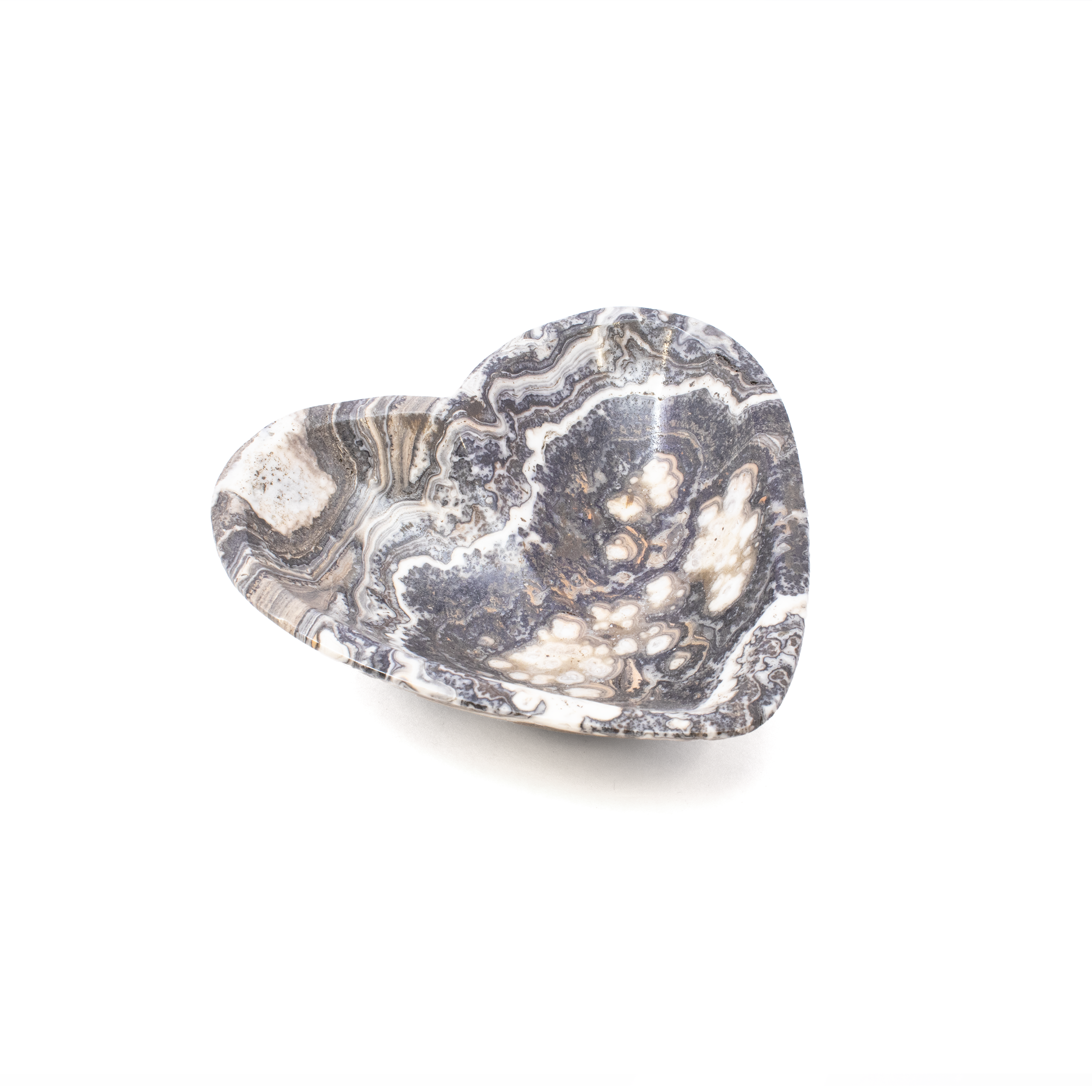 Introducing the Zebra Onyx Heart Vessel, a stunning piece of art and nature combined to add elegance and tranquility to any space. Crafted from exquisite Mexican Onyx, this heart-shaped vessel showcases the unique patterns and natural beauty of Zebra Onyx, with its striking bands of black, white, and grey tones. Each piece is one-of-a-kind, as the minerals form organically over time, ensuring that no two vessels are exactly alike.Perfectly polished to a smooth finish, the Zebra Onyx Heart Vessel serves as both a decorative piece and a functional item. Use it as a centerpiece to hold small treasures, trinkets, or potpourri, or simply display it on a shelf or table to admire its intricate patterns and vibrant elegance. Zebra Onyx Heart Vessel