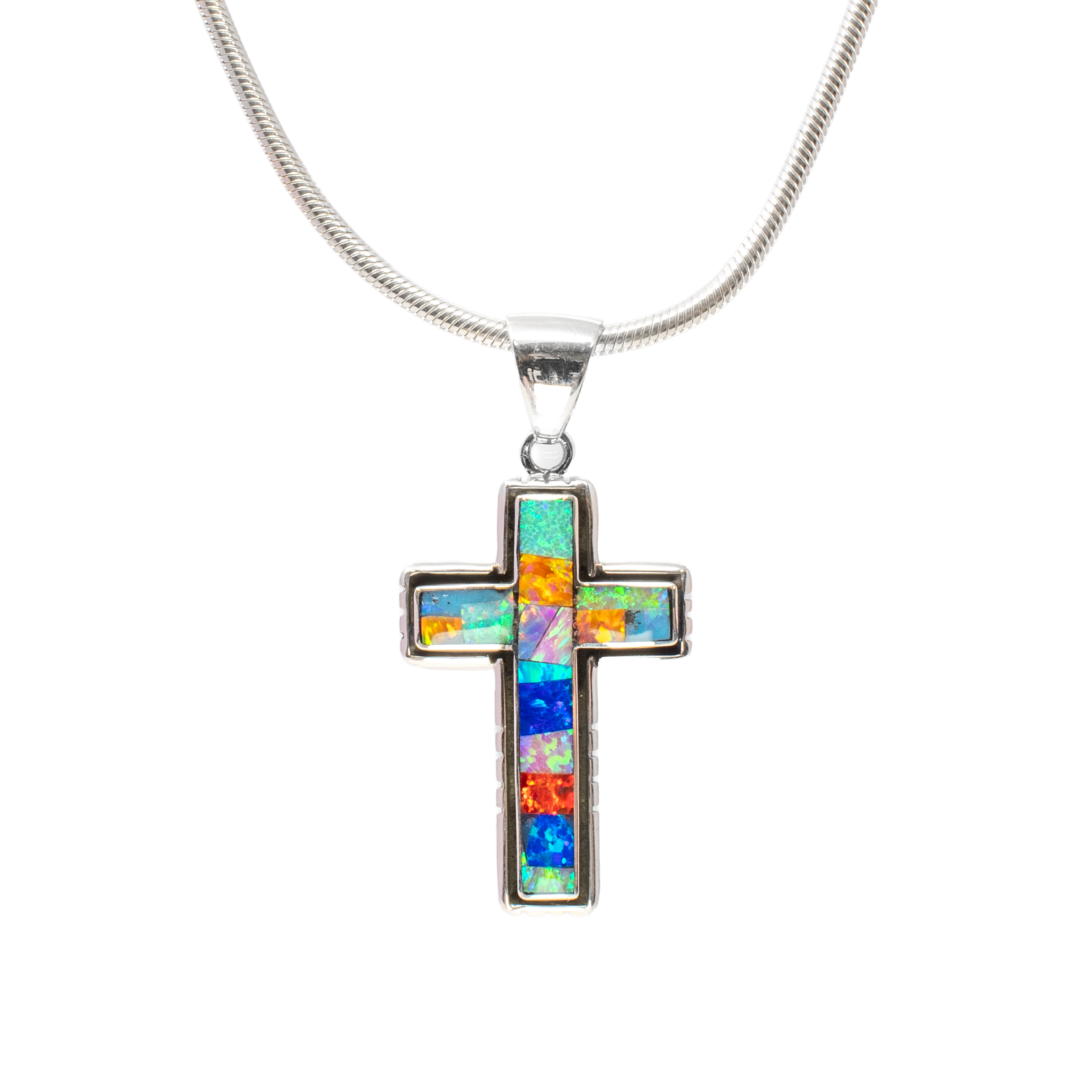 Elevate your jewelry collection with this exquisite Multi Fire Opal Inlay Cross Pendant, a true masterpiece of craftsmanship and elegance. This stunning pendant features a rectangular inlay of vibrant white opal, radiating an enchanting spectrum of colors that mimic the mesmerizing allure of a twilight sky.Crafted with precision, the opal inlay is beautifully set within a sophisticated 925 sterling silver channel, enhancing the pendant's luminous beauty. The sterling silver is carefully oxidized, lending a touch of vintage charm to the piece while highlighting the intricate details of the design. Multi Fire Opal Inlay Cross Pendant - Rectangular Inlay with White Opal & 925 Sterling Silver Channeling & Oxidized Bezel Edge with Stamping