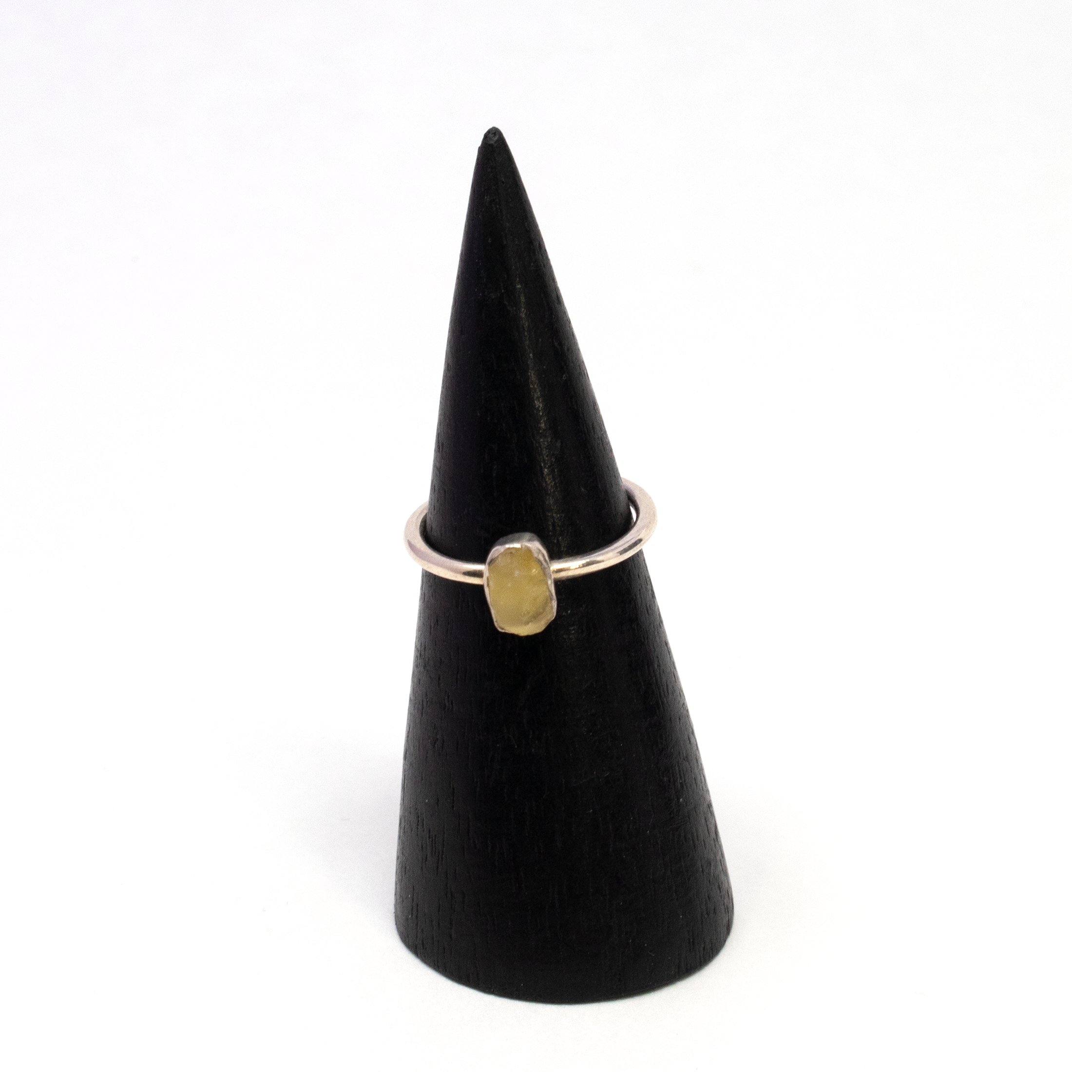 Introducing our exquisite Egyptian Tektite Ring, a remarkable piece of jewelry that transports you to the mystical sands of the Sahara Desert in Libya. This unique ring features a genuine Libyan Yellow Tektite, renowned for its captivating golden hue and cosmic origins. Crafted with elegance in mind, the tektite showcases its natural, rough dainty freeform shape, making each piece truly one-of-a-kind.The gemstone is beautifully set in a simple yet sophisticated 925 sterling silver bezel, highlighting its ethereal beauty while ensuring durability and longevity. The bezel setting sits gracefully atop a vertically oriented band, adding a modern twist to this ancient wonder. Designed in a size 4, the ring offers both comfort and style, making it a perfect fit for those who appreciate dainty and minimalist jewelry. Egyptian Tektite Ring from Sahara Desert of Libya - Rough Dainty Freeform with Simple 925 Sterling Silver Bezel on Vert Band sz4